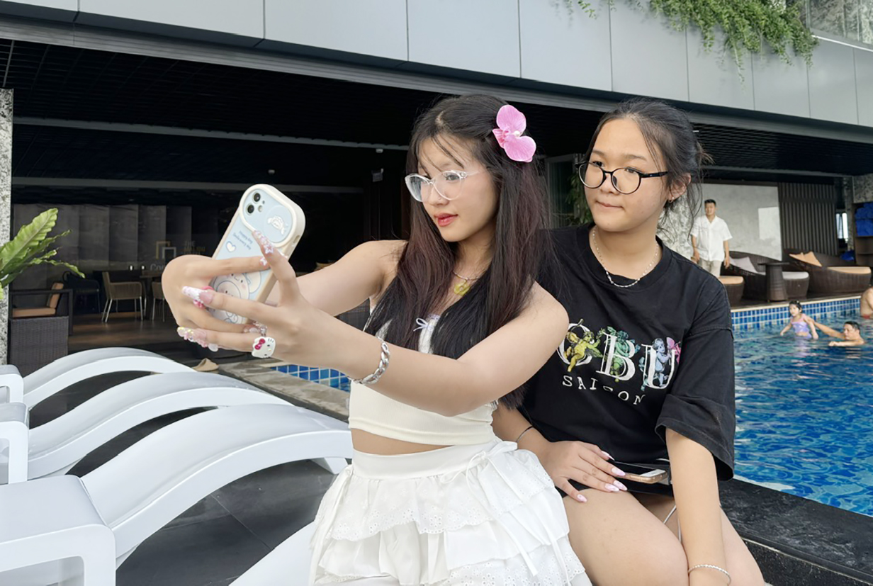 Em Huỳnh Nguyễn Minh Anh (bên trái) selfie cùng người thân  tại hồ bơi Malibu Hotel Vũng Tàu.
