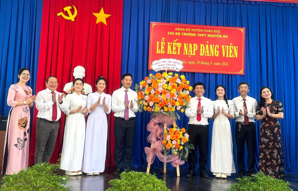 Ông Lê Thanh Liêm, Phó Bí thư Huyện ủy Châu Đức tặng hoa chúc mừng Chi bộ Trường THPT Nguyễn Du kết nạp đảng viên mới. Ảnh: ĐẶNG HOÀI