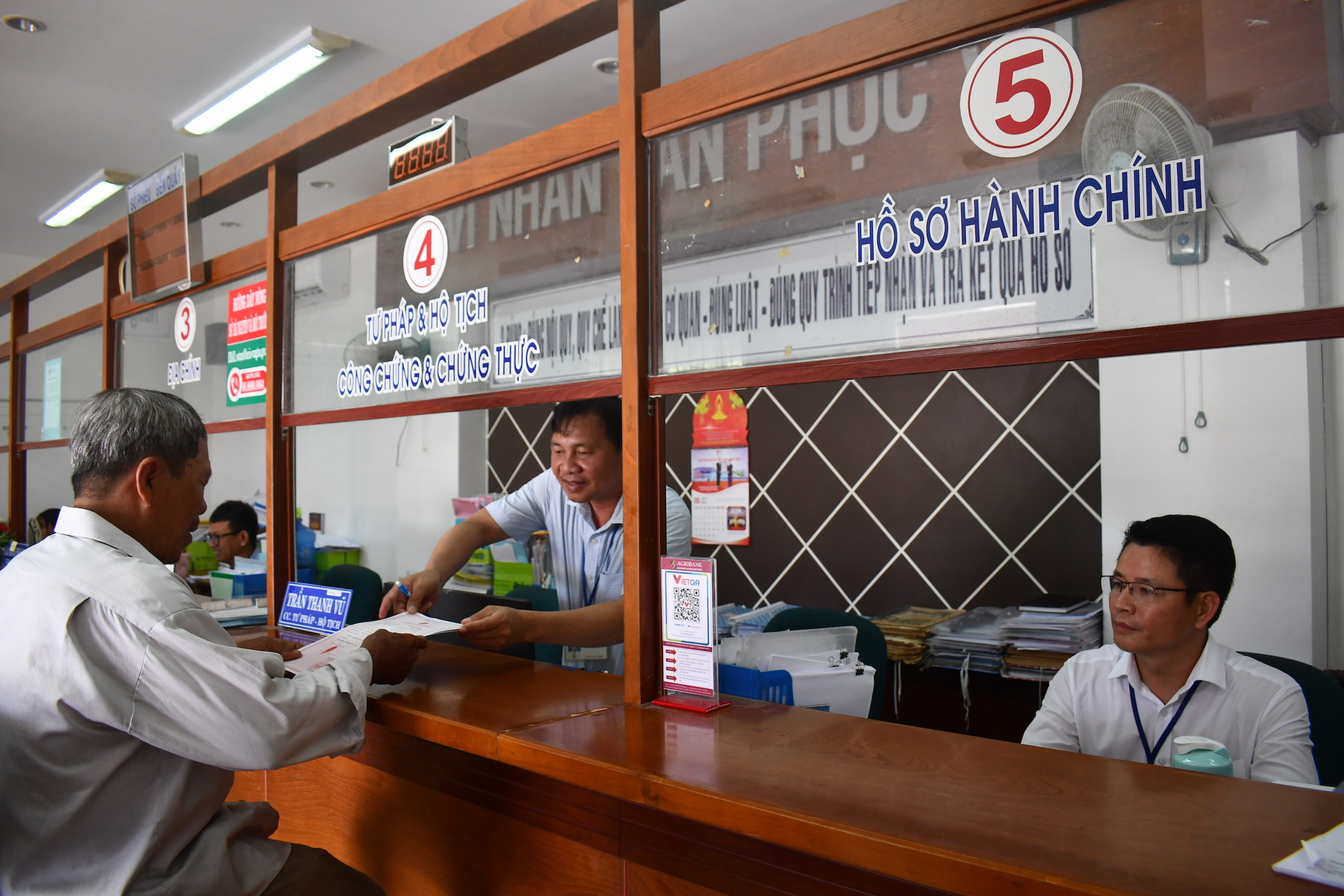 Thứ trưởng Bộ Công an Lê Quốc Hùng đánh giá việc thực hiện đề án của tỉnh Bà Rịa - Vũng Tàu được tiến hành kịp thời, đúng quy định, có các chính sách về bố trí công việc, hỗ trợ cho cán bộ, người lao động dôi dư sau sắp xếp. Trong ảnh: Công chức Bộ phận một cửa UBND xã An Ngãi, huyện Long Điền hướng dẫn thủ tục hành chính cho người dân.