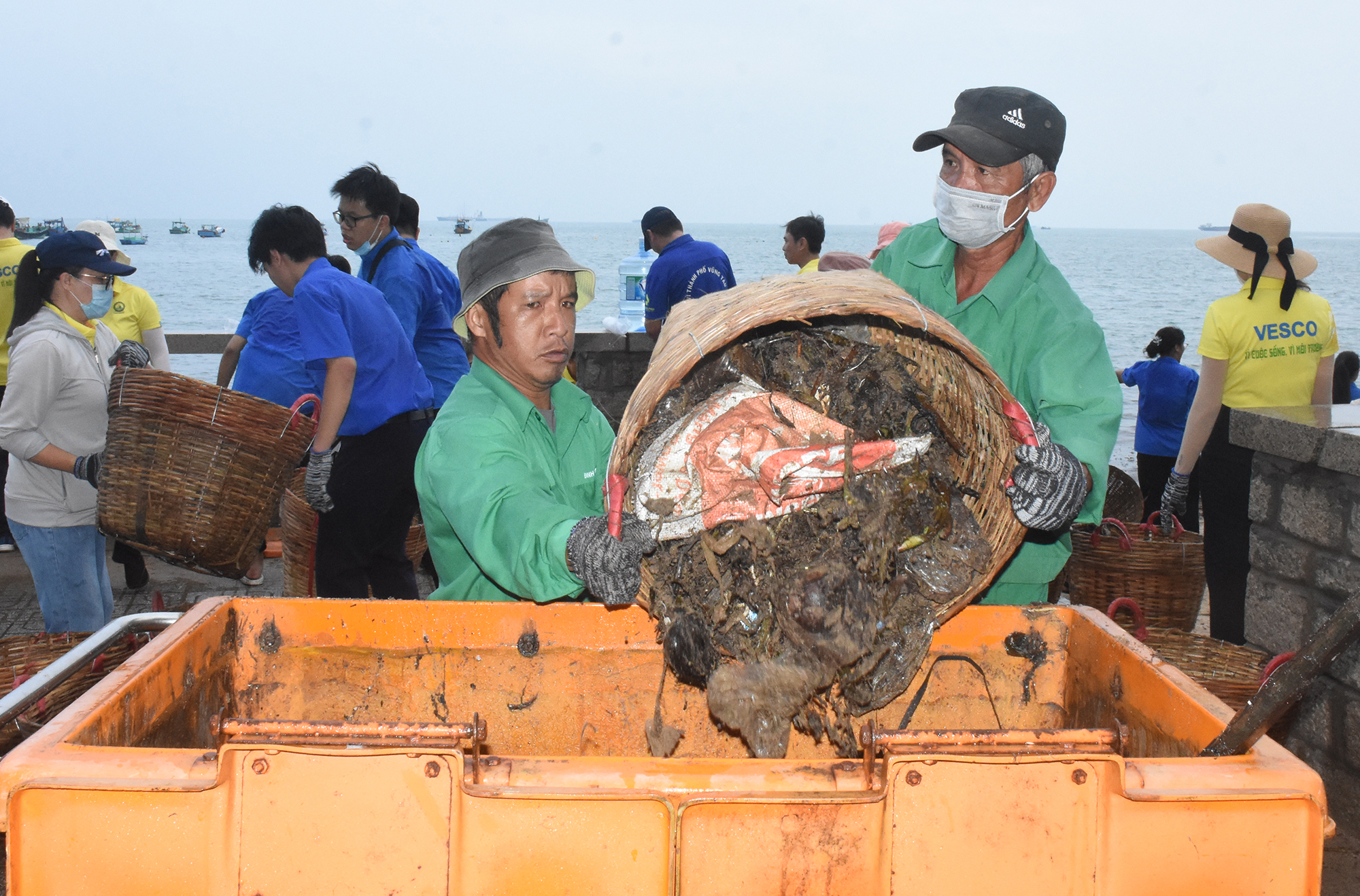 Công nhân VESCO đưa rác lên thùng, đẩy ra xe chuyên dụng
