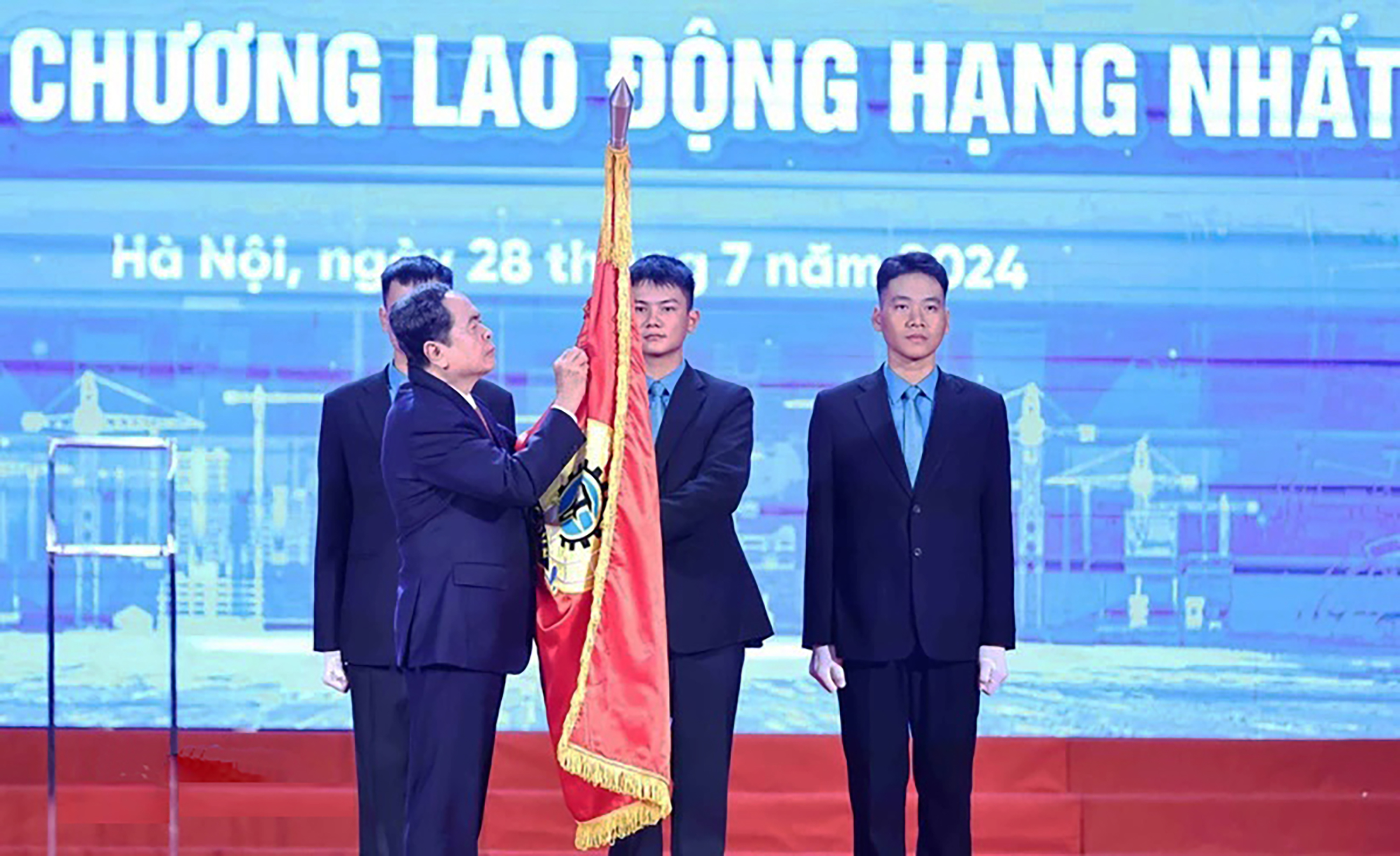 Chủ tịch Quốc hội Trần Thanh Mẫn gắn Huân chương Lao động hạng Nhất lên cờ truyền thống của Tổng Liên đoàn Lao động Việt Nam.