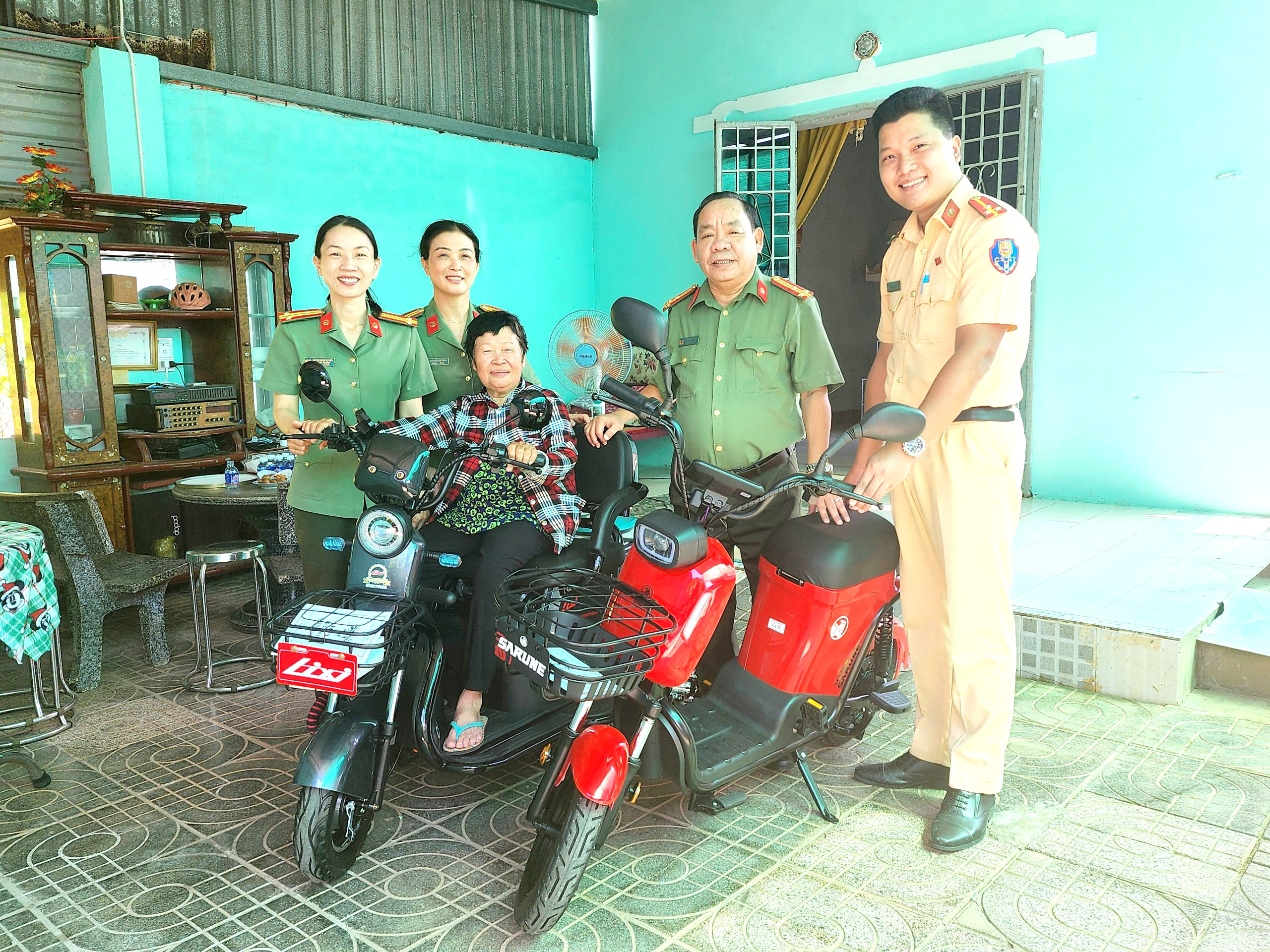 Đại diện lãnh đạo Công an TP.Bà Rịa trao xe điện và xe đạp  cho gia đình bà Lê Thị Vạn.