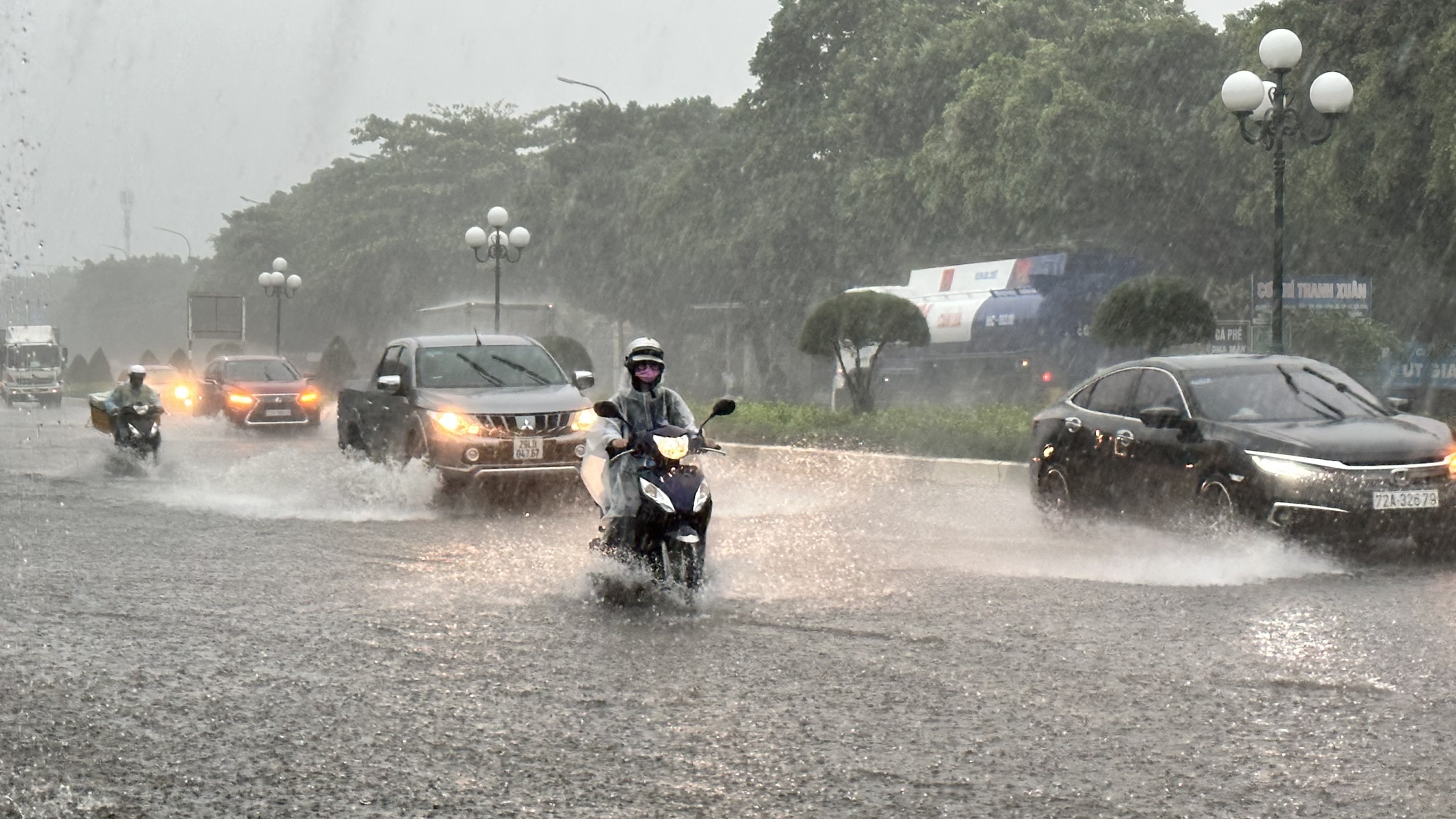 Người và phương tiện di chuyển dưới trời mưa lớn  trên tuyến đường Võ Nguyên Giáp (TP.Vũng Tàu).
