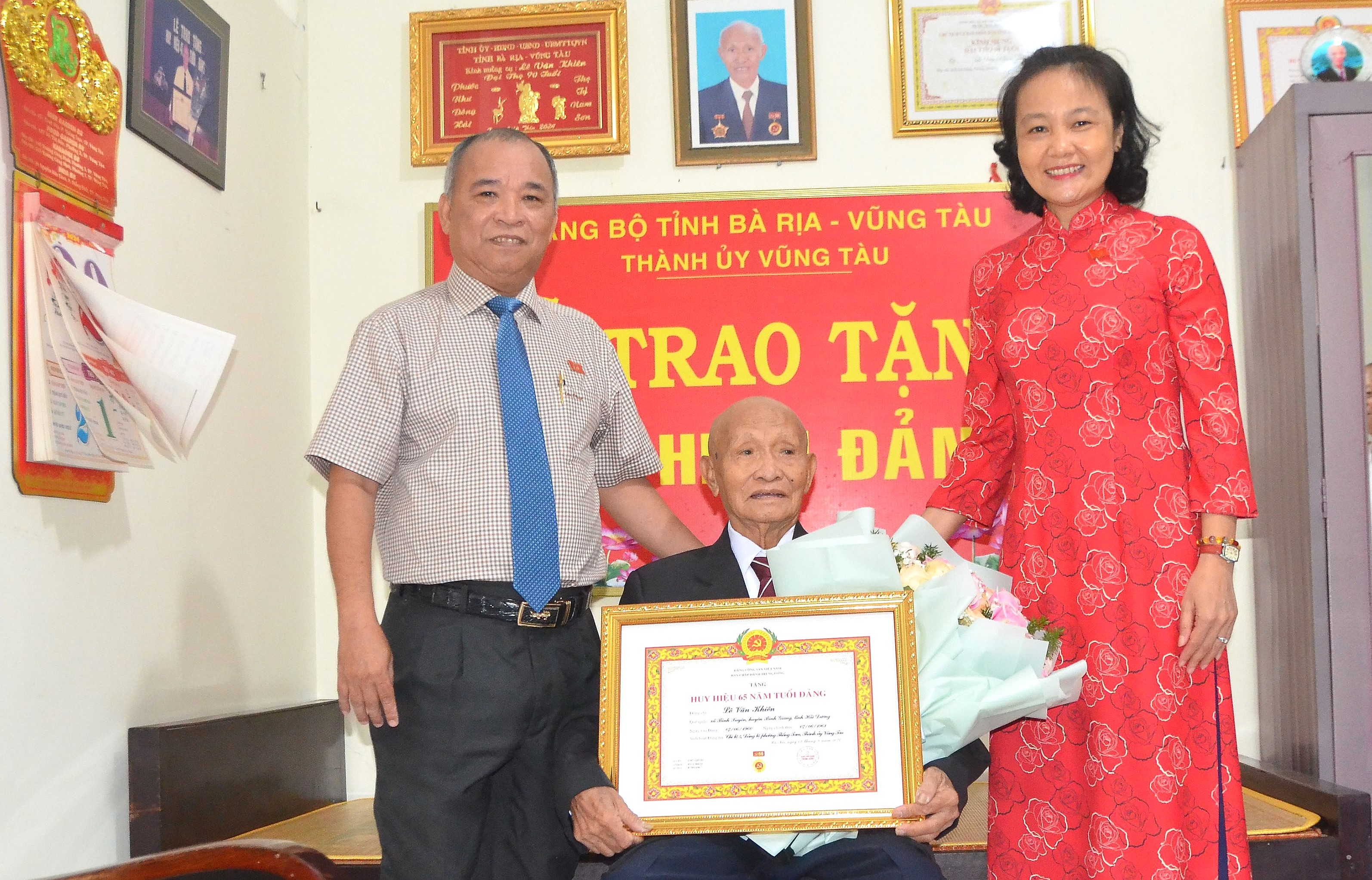 Bà Nguyễn Thị Ngọc Thủy, Trưởng Ban Tổ chức Thành ủy Vũng Tàu cùng ông Trần Bá Việt, Bí thư Đảng ủy phường Thắng Tam trao Huy hiệu 65 năm tuổi Đảng cho đảng viên Lê Văn Khiên (420 Lê Hồng Phong).