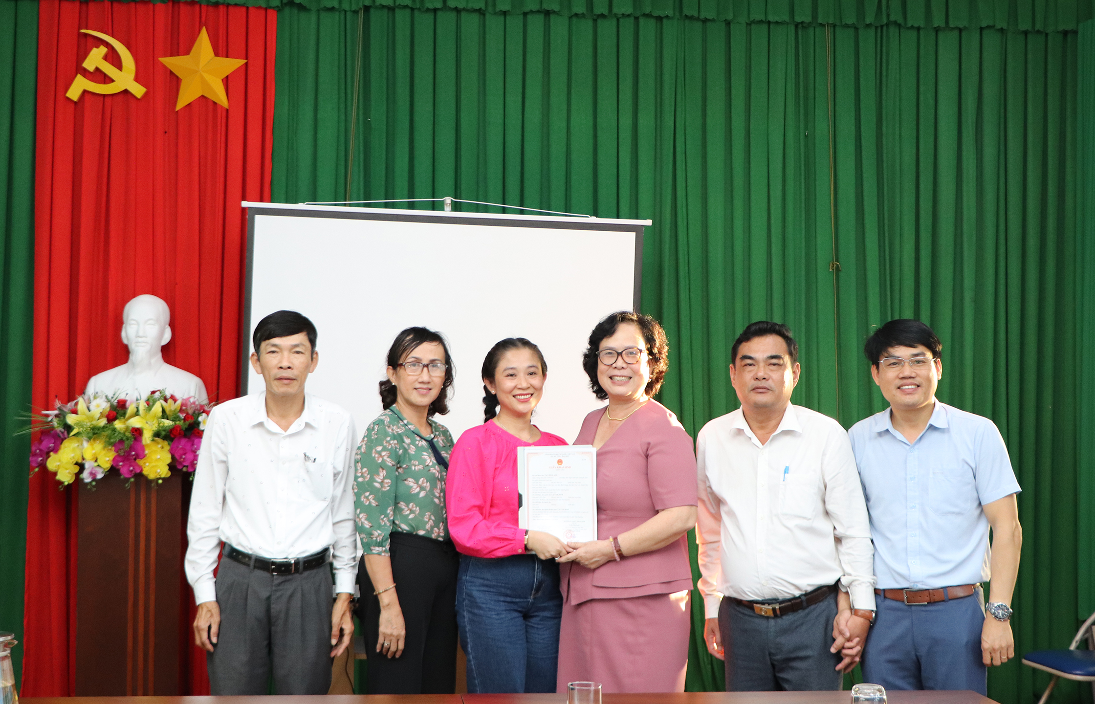 Bà Nguyễn Vân Anh, Phó Giám đốc Sở LĐTBXH và đại diện Trung tâm Trung tâm Công tác Xã hội trao Giấy khai sinh tới đại diện gia đình em Minh Anh.