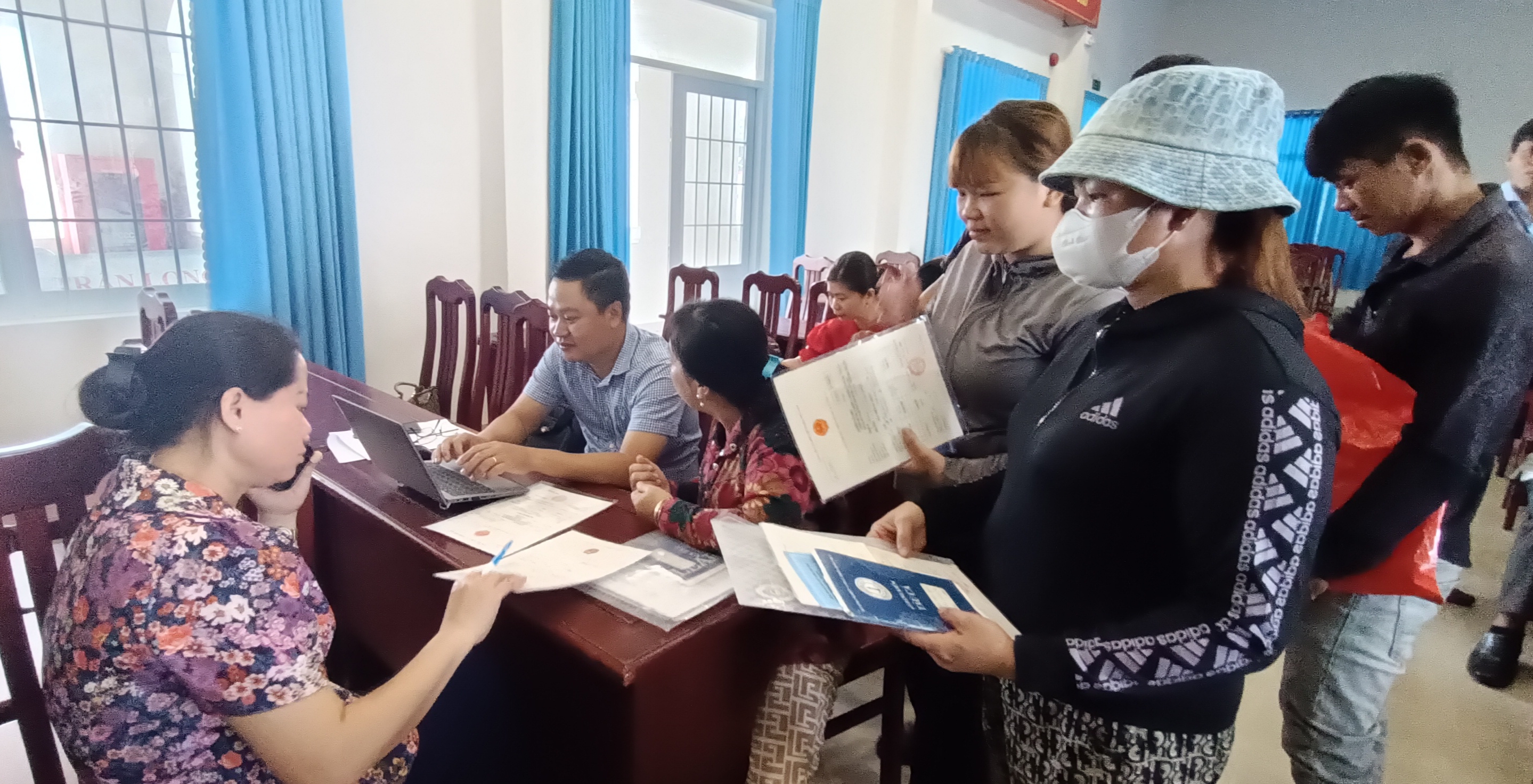 Bà Phạm Thị Na, Phó Giám đốc Sở NN-PTNT (bên trái) cùng cán bộ Chi cục Thủy sản hướng dẫn thủ tục cho từng trường hợp để chủ tàu cá hoàn thiện giấy tờ đi khai thác