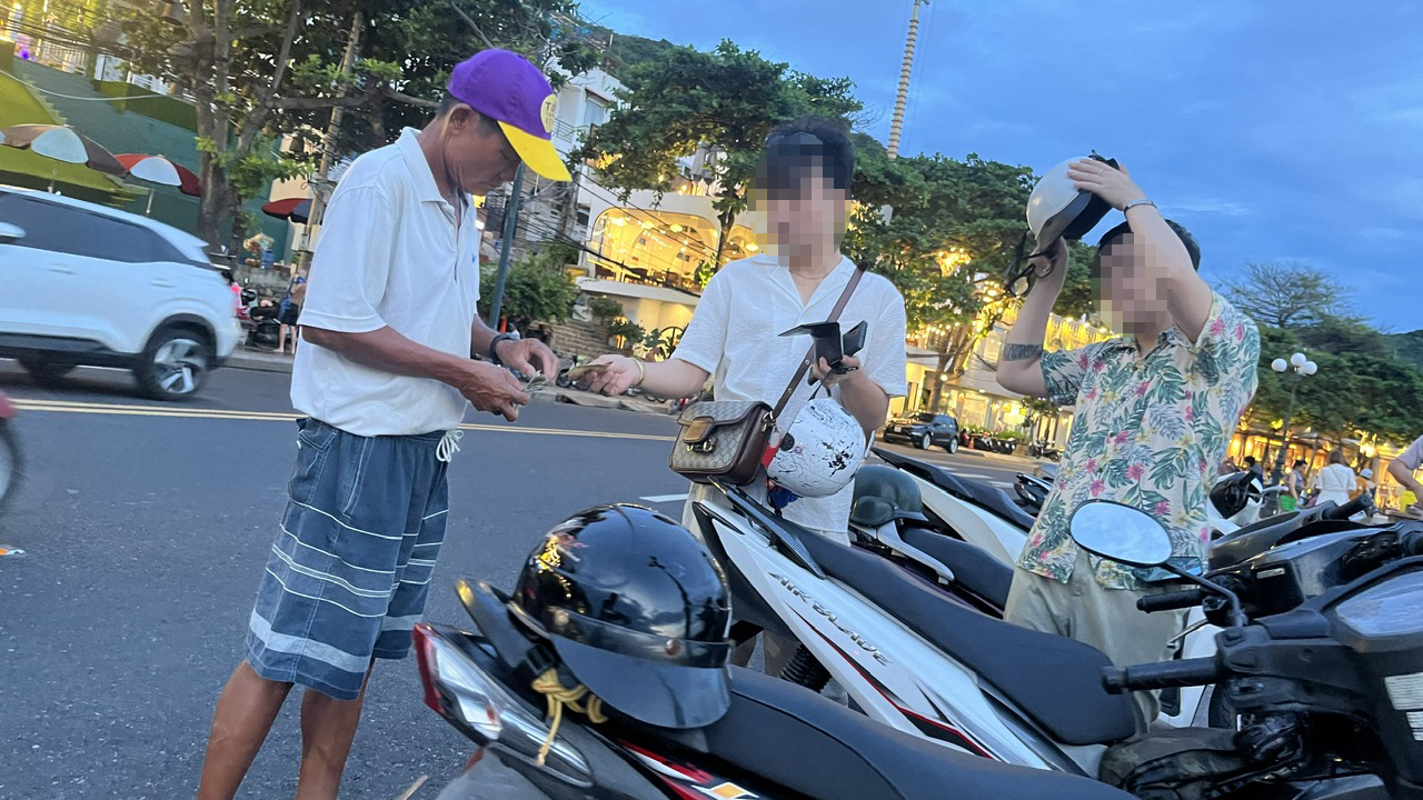 Một người đàn ông thu phí giữ xe máy dưới lòng đường Hạ Long (đoạn đối diện hẻm 66 Hạ Long).