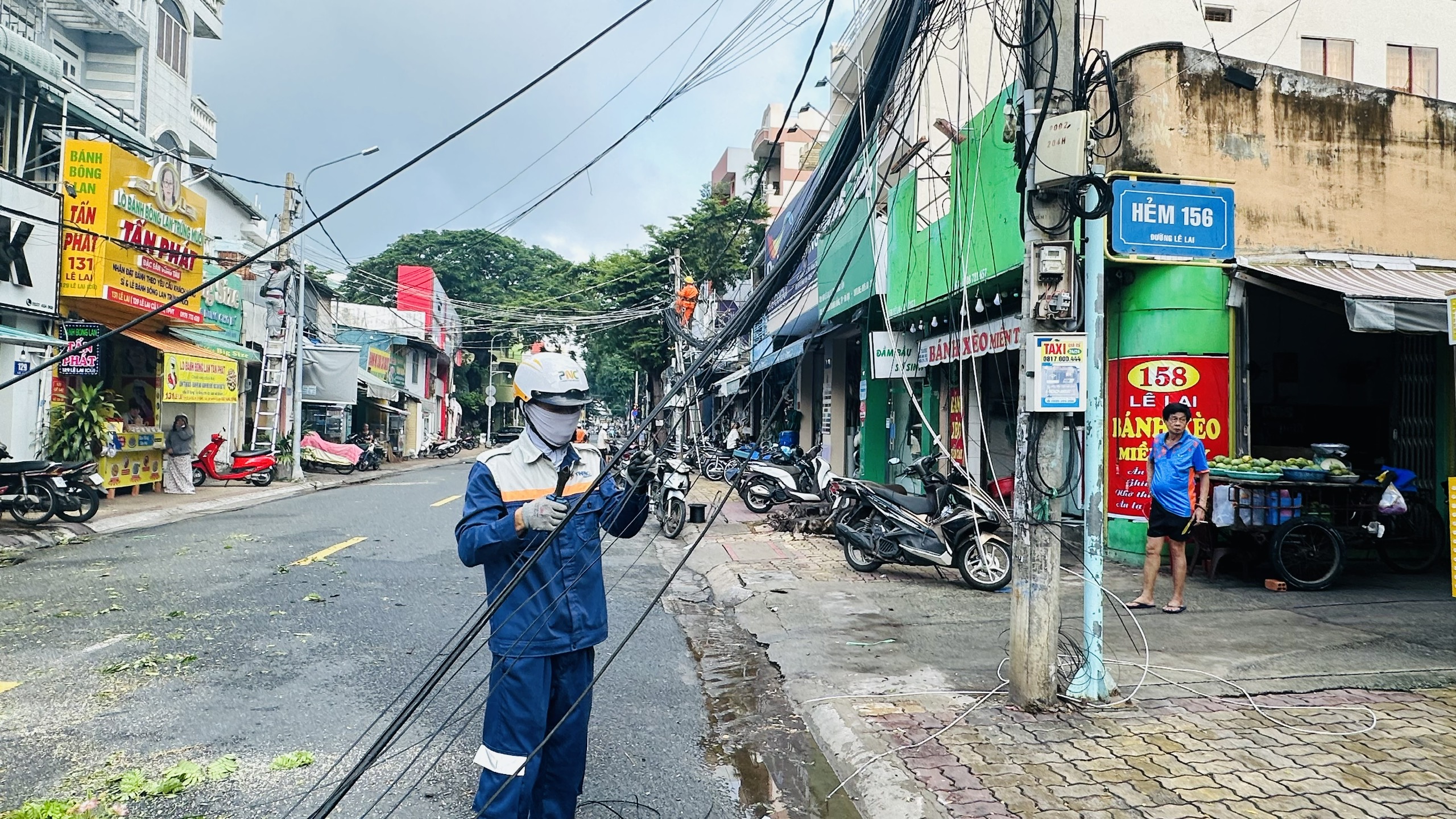 Sự cố làm đổ cột điện, dứt dây điện và cáp viễn thông. Trong ảnh: Nhân viên nhà mạng FPT đến hiện trường xử lý sự cố