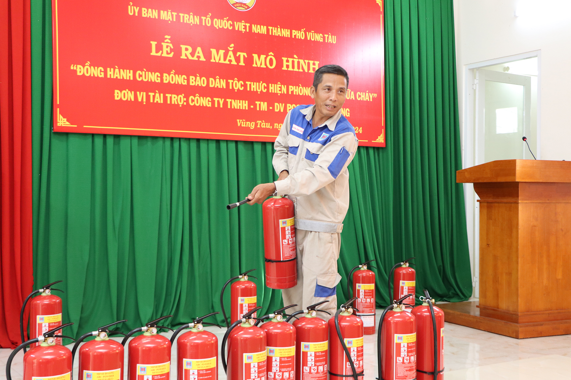 Nhân viên kỹ thuật của Công ty TNHH Thương mại Dịch vụ PCCC Minh Hoàng hướng dẫn người dân sử dụng bình chữa cháy xử lý đám cháy.