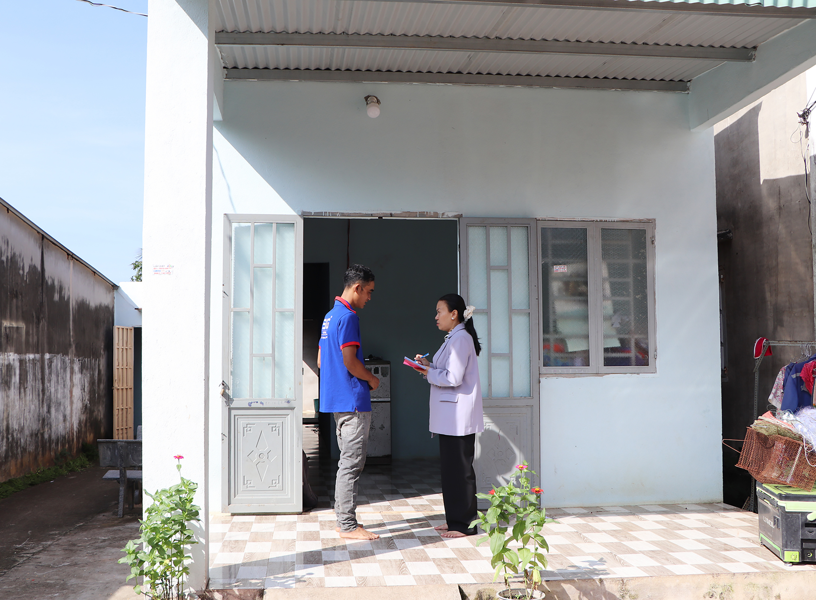 Anh Lý Văn Tấn, xã Bàu Chinh trao đổi với cán bộ xã về niềm vui có căn nhà khang trang, vững chắc.