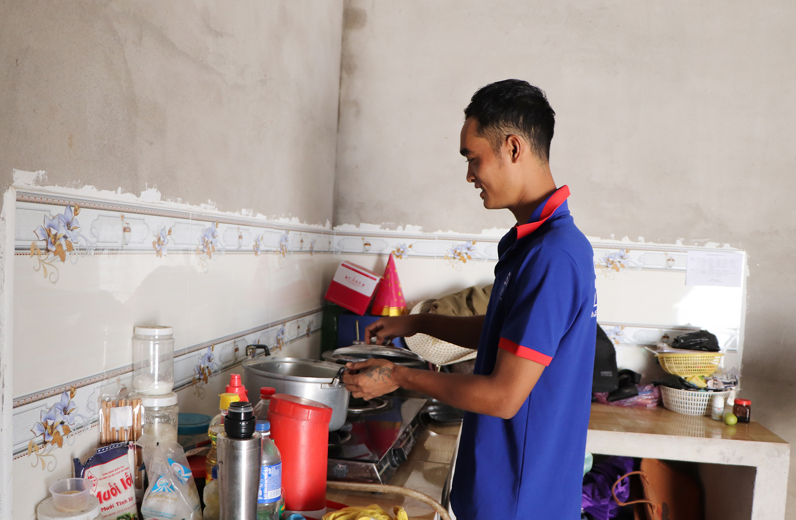  Anh Lý Văn Tấn, xã Bàu Chinh chuẩn bị bữa ăn trưa cho cả gia đình trong căn bếp mới.