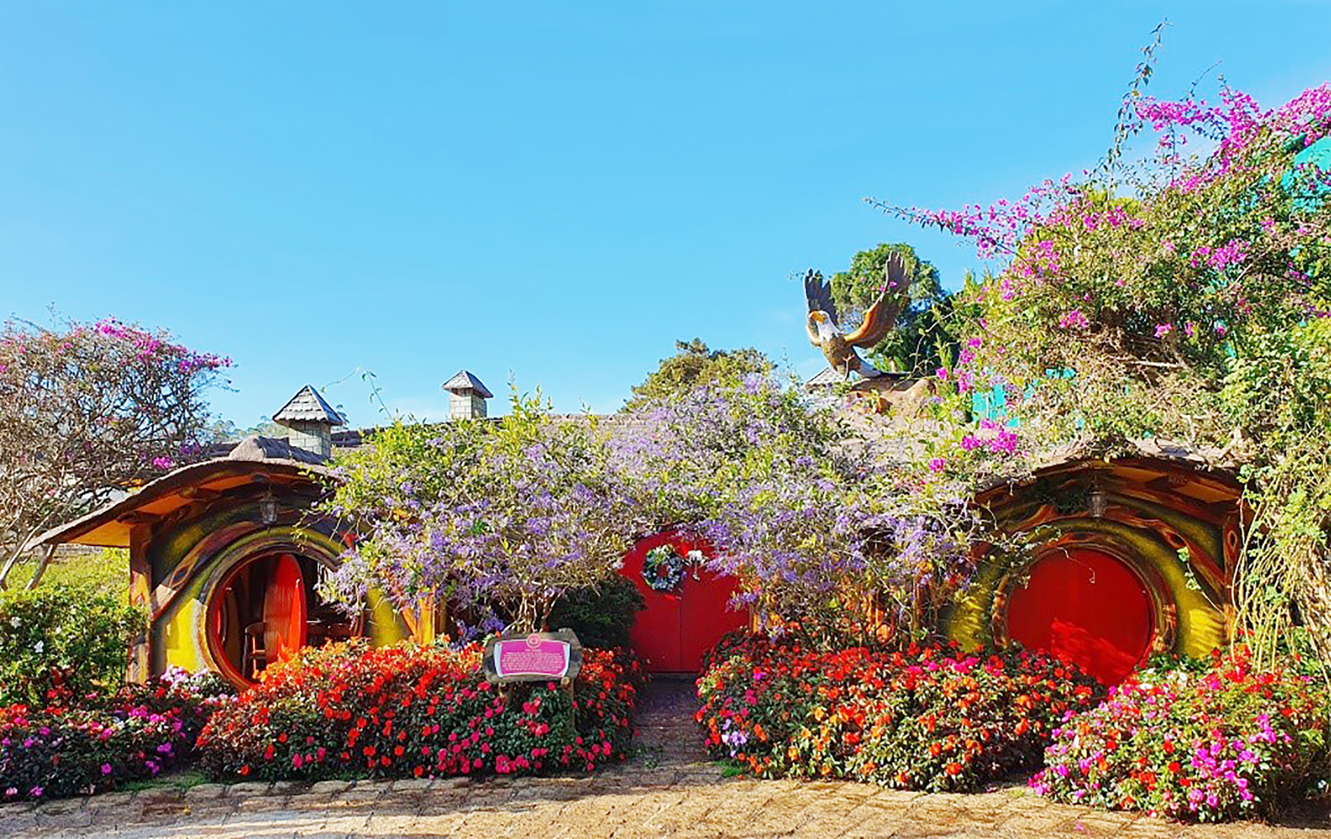 Những ngôi nhà Hobbit được bao quanh bởi những khóm hoa rực rỡ và rừng cây leo xanh mát. Ảnh: dalatfairytaleland.com