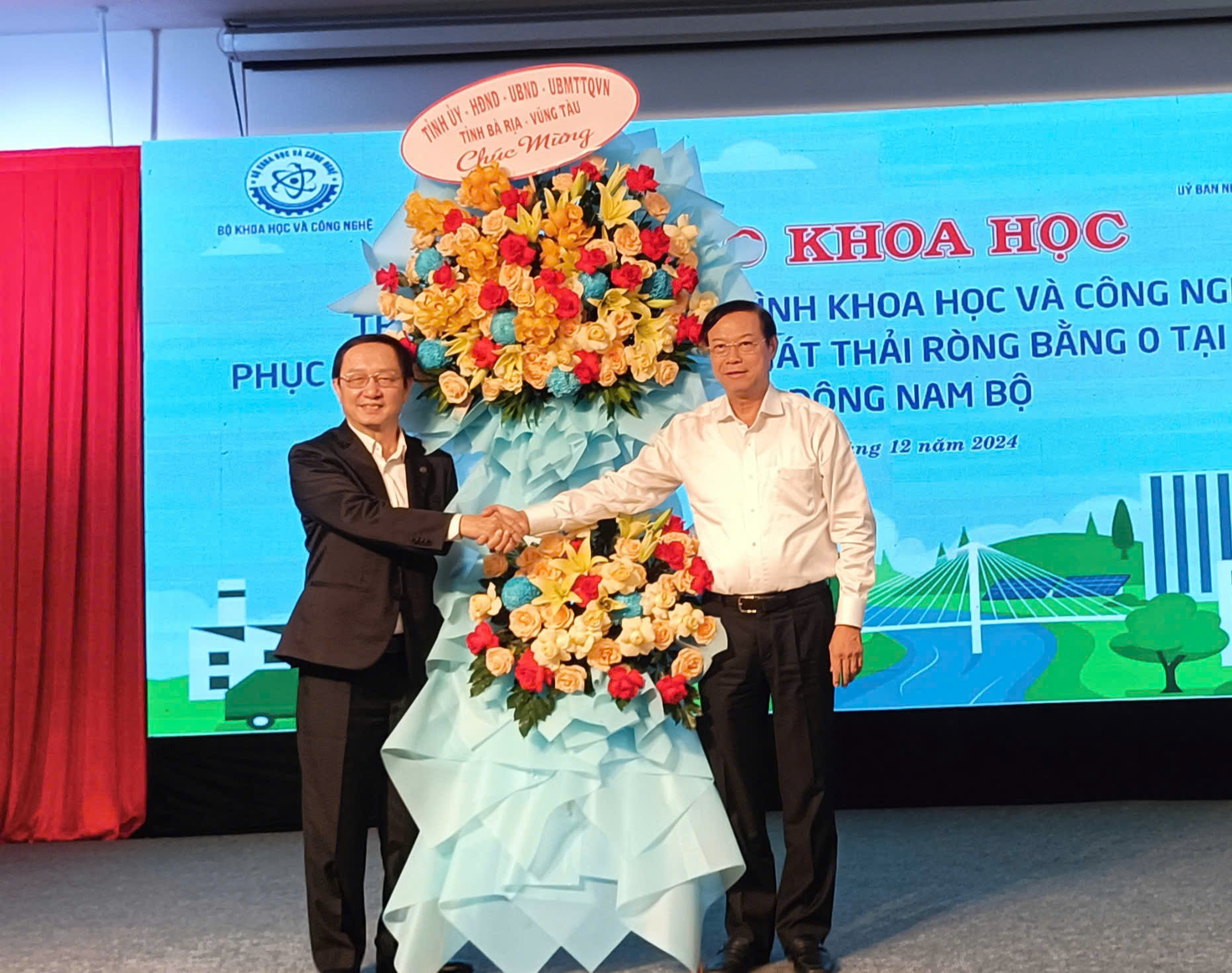 Chủ tịch UBND tỉnh BRVT Nguyễn Văn Thọ (bên phải) tặng hoa cho Bộ trưởng Bộ KH-CN Huỳnh Thành Đạt.