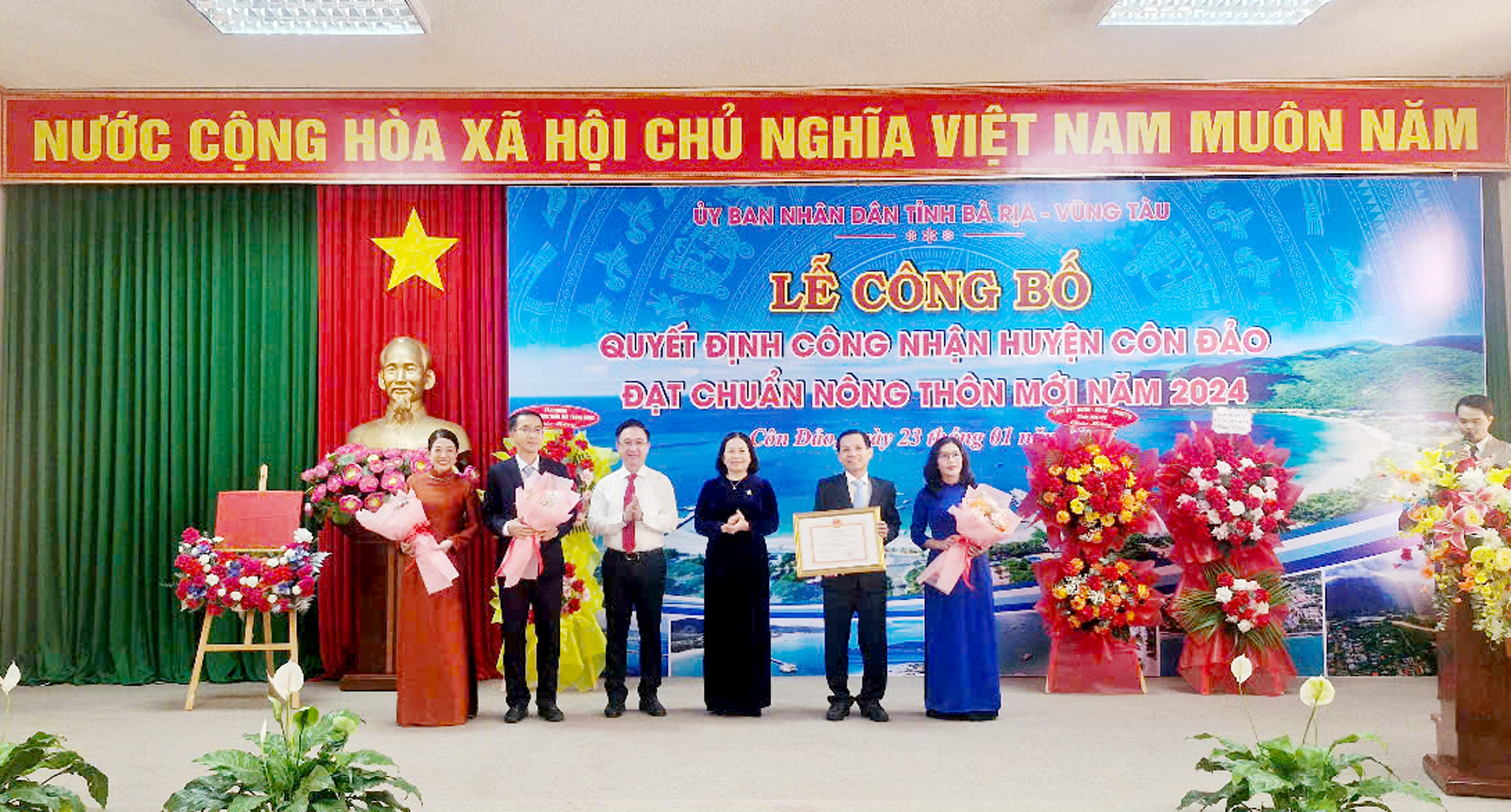 Bà Nguyễn Thị Yến, Phó Bí thư Thường trực Tỉnh ủy, Trưởng Đoàn ĐBQH tỉnh và ông Đặng Minh Thông, Phó Chủ tịch UBND tỉnh trao quyết định công nhận huyện NTM và hoa cho lãnh đạo huyện Côn Đảo.