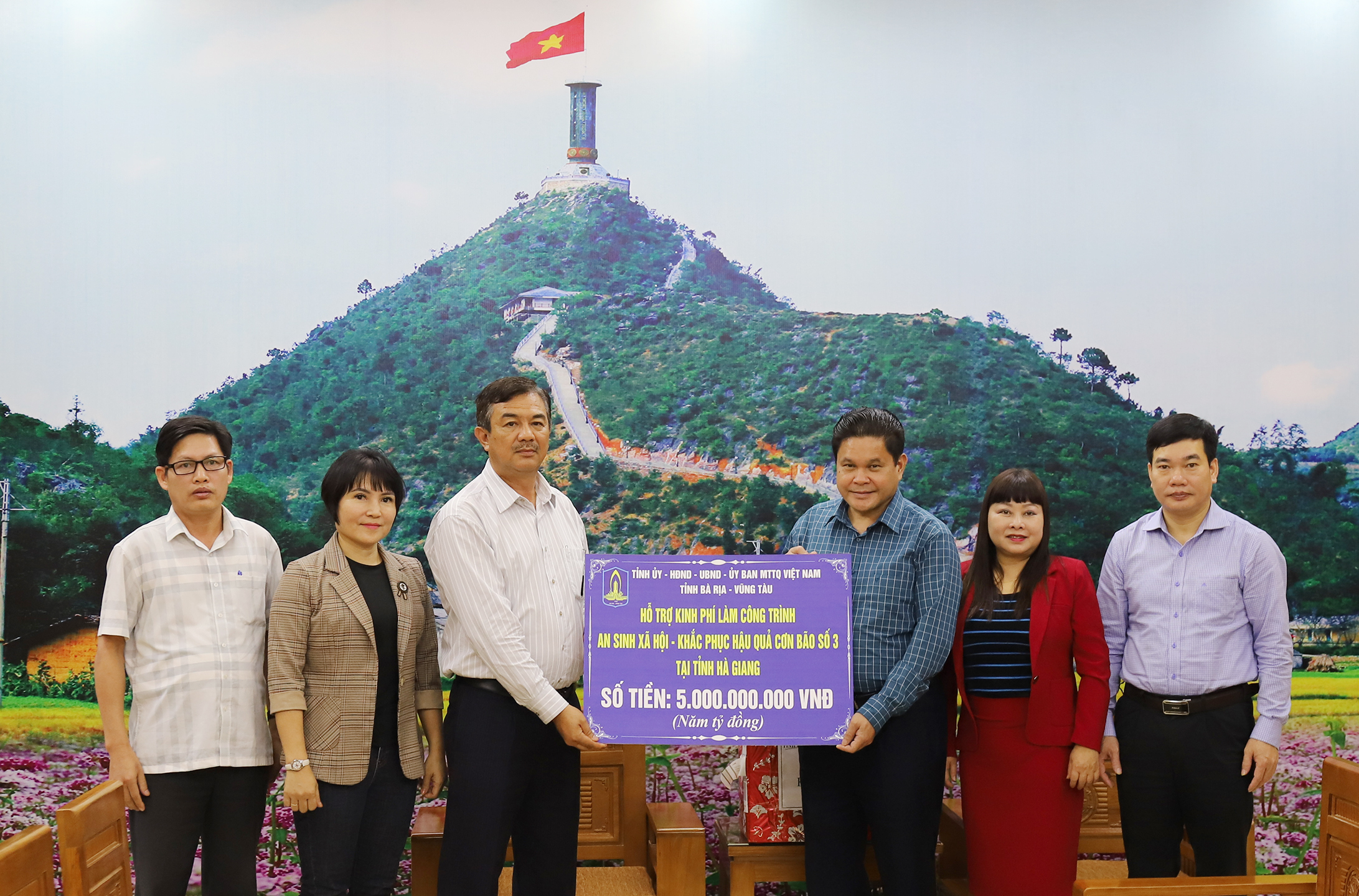 Phó Chủ tịch UBMTTQ Việt Nam tỉnh Trịnh Hàng trao bảng tượng trưng số tiền 5 tỷ đồng tới đại diện UBMTTQ Việt Nam tỉnh Hà Giang.