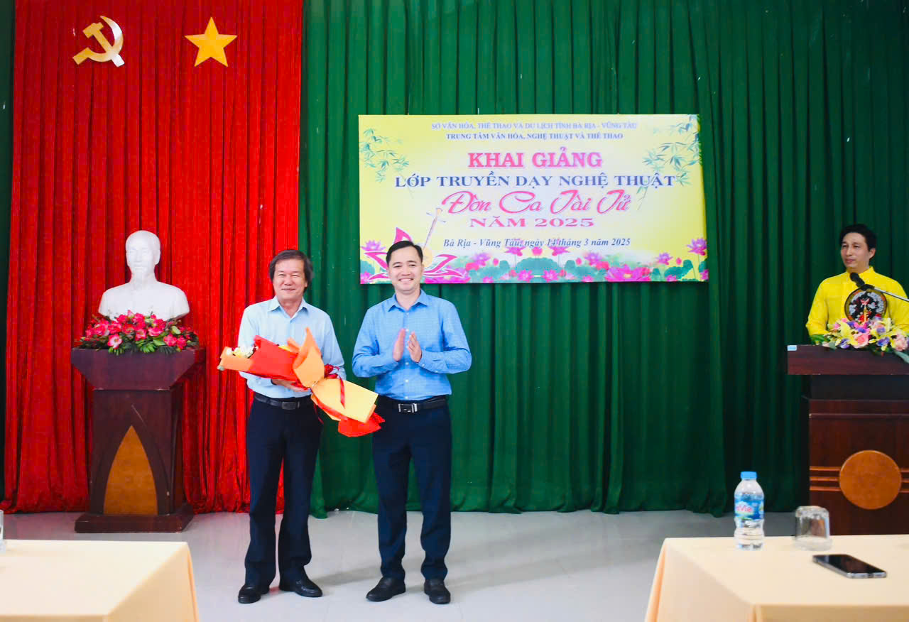 Ông Trần Thế Vinh, Giám đốc Trung tâm Văn hóa Nghệ thuật và Thể thao tỉnh tặng hoa đến NSƯT Huỳnh Khải