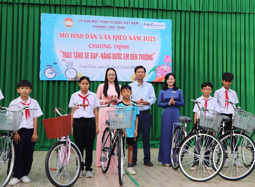 Đại diện UBMTTQ Việt Nam phường Long Toàn, nhà hảo tâm và lãnh đạo Trường THCS Long Toàn trao xe đạp cho HS khó khăn.