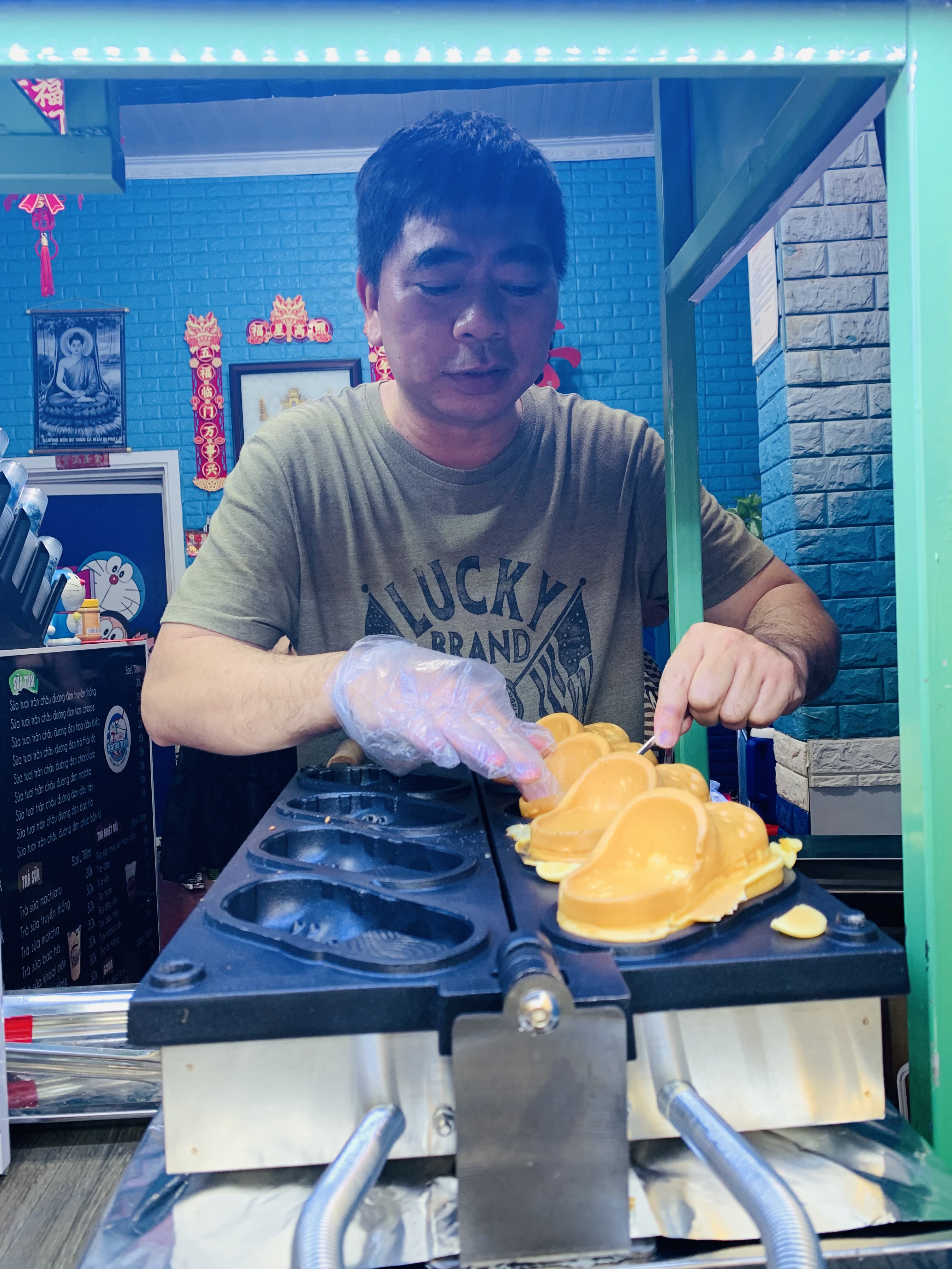 Anh Quách Quang Huy, chủ tiệm “Bánh dép cá sấu” nướng những chiếc bánh hình dép thơm ngon phục vụ khách.