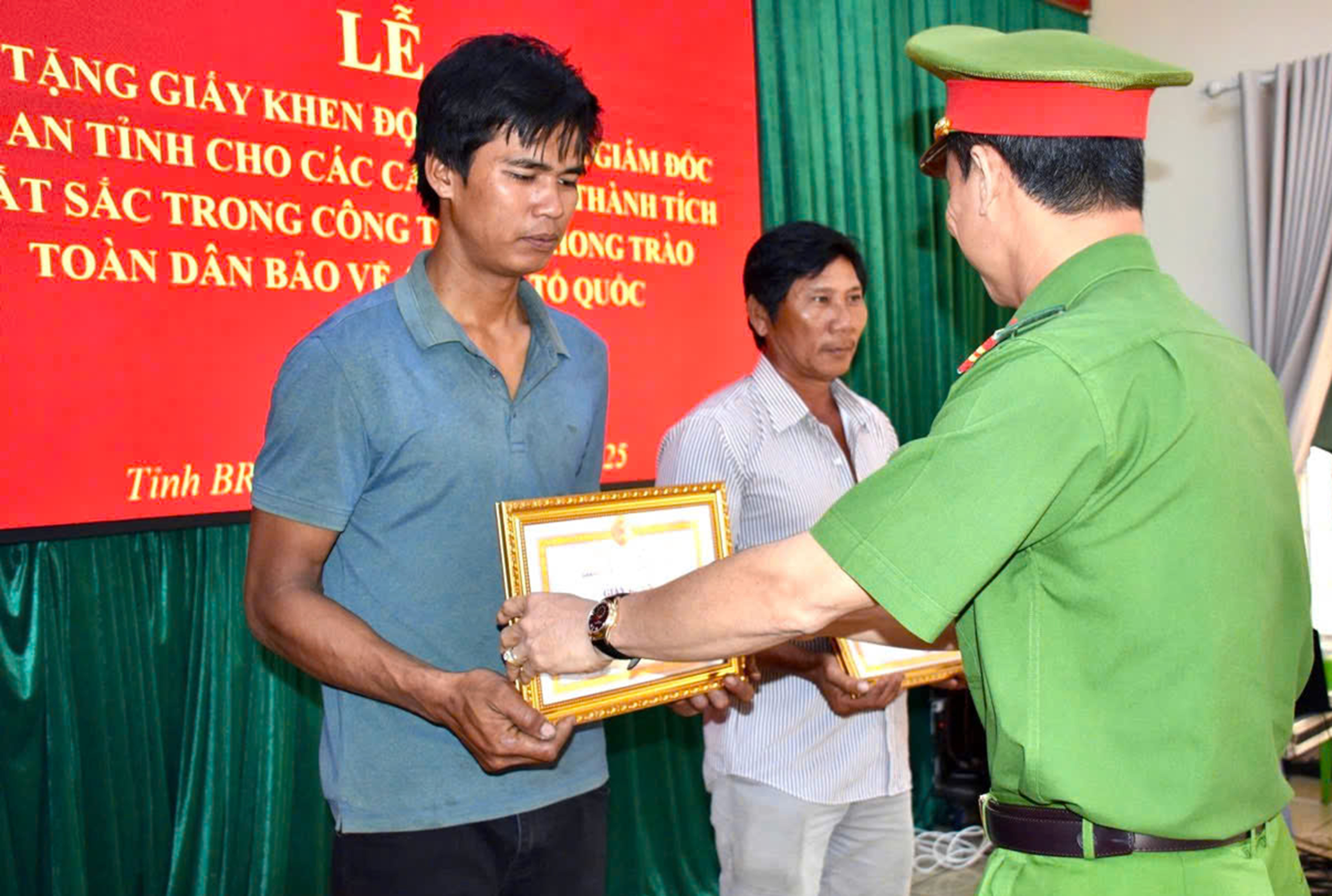 Đại tá Nguyễn Anh Hùng, Phó Giám đốc Công an tỉnh trao quyết định khen thưởng đột xuất cho ông Nguyễn Văn Sỹ và anh Lê Văn Hậu.