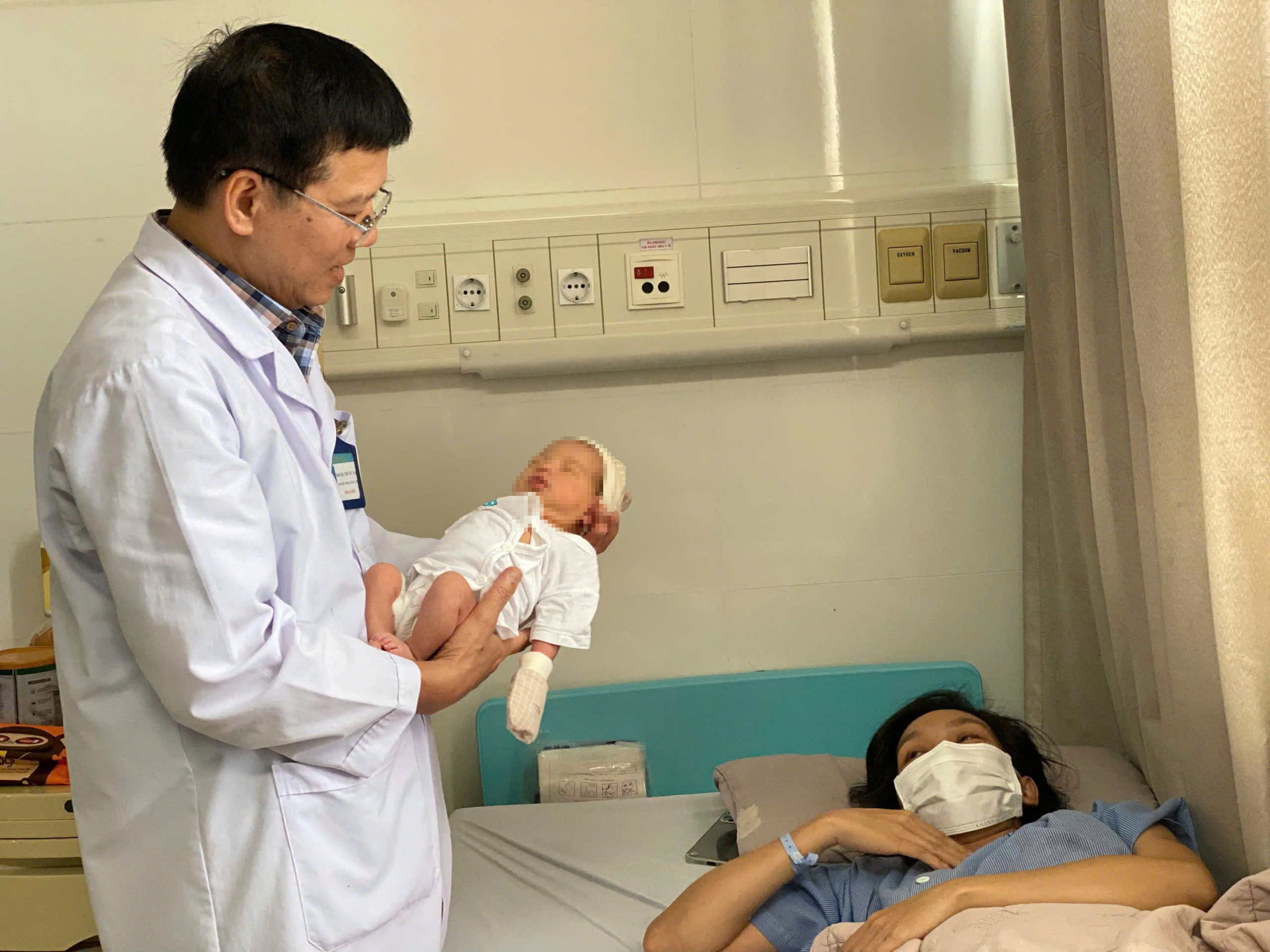 Bác sĩ Hoàng Phước Ba, Trưởng Khoa Phụ sản (Bệnh viện Vũng Tàu) kiểm tra sức khỏe cho hai mẹ con sản phụ.