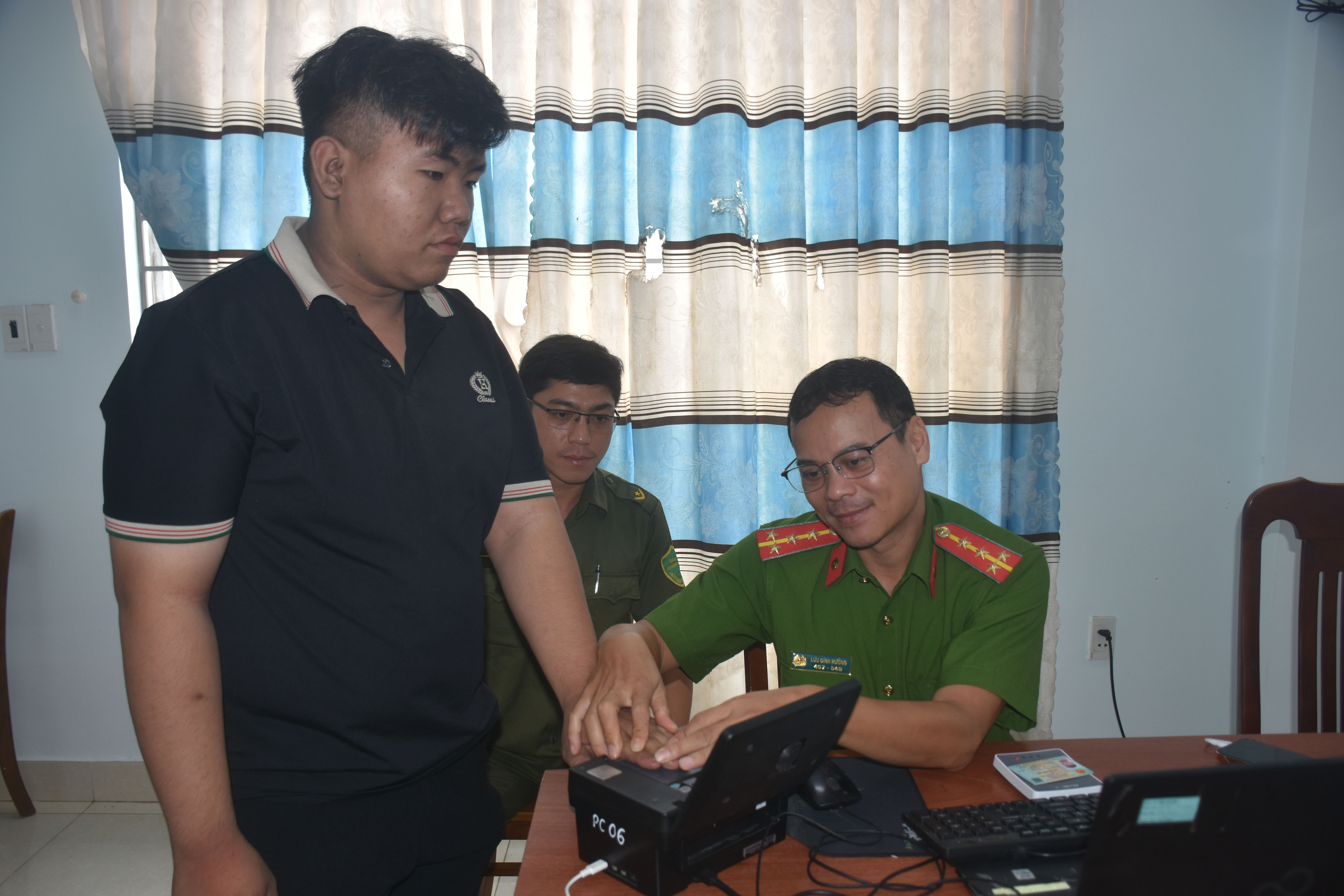 Cán bộ Công an tỉnh lăn tay cấp tài khoản định danh điện tử mức độ 2 cho người dân.