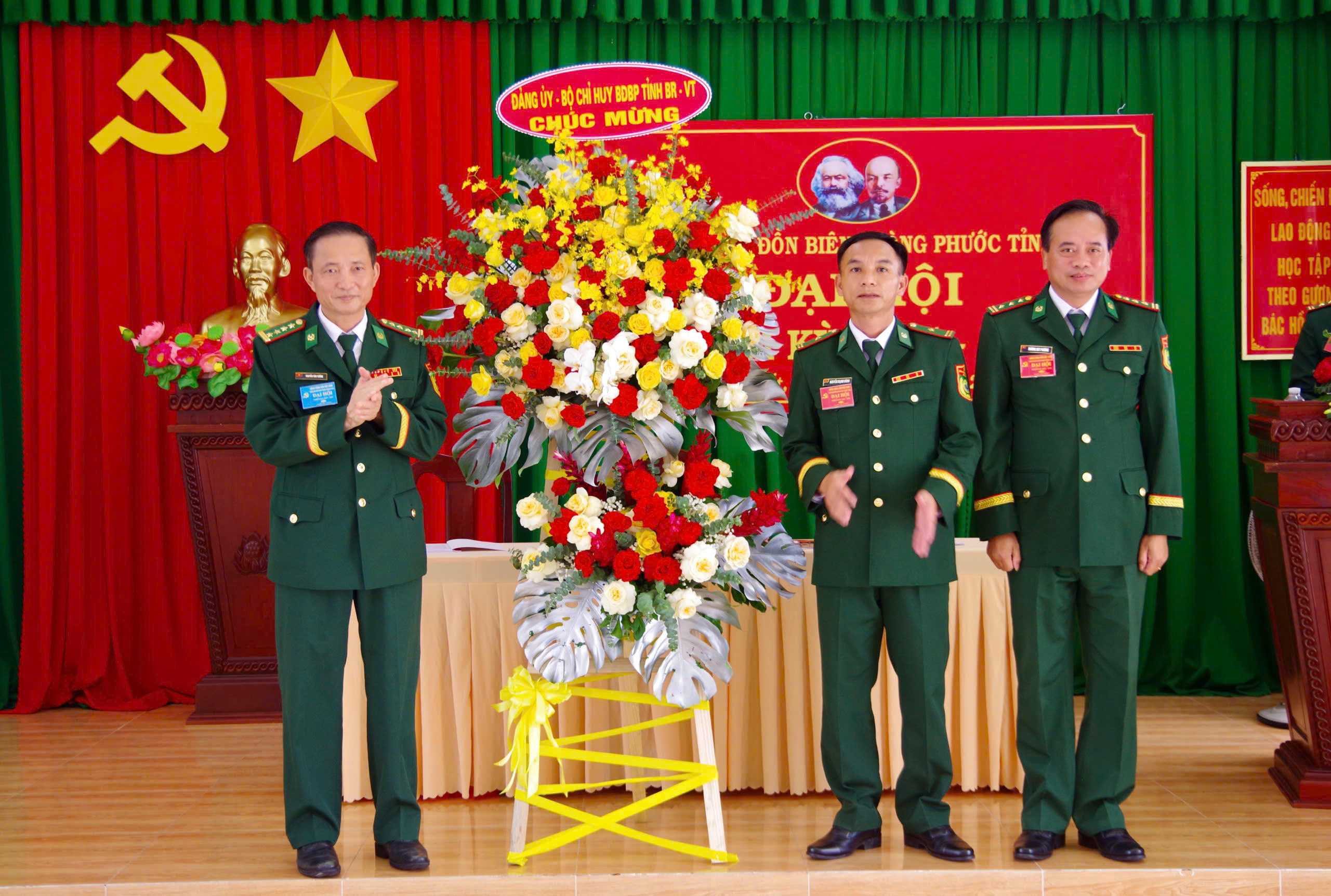 Đại tá Nguyễn Văn Thống, Ủy viên Ban Thường vụ Đảng ủy, Phó Chính ủy Bộ đội Biên phòng tỉnh (bìa trái) tặng hoa chúc mừng đại hội.