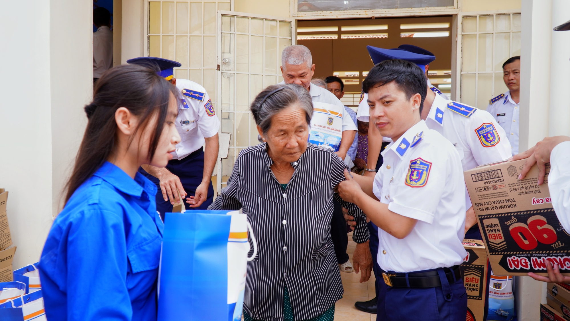 Đoàn viên thanh niên các đơn vị hỗ trợ bà con Nhân dân nhận quà.