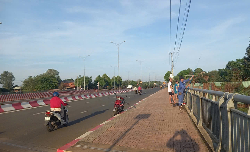 Nếu không quan sát khi quăng cần thì dây câu có thế vướng vào người đi đường bất cứ lúc nào. Trong ảnh: Người dân câu cá trên cầu sông Dinh (TP.Bà Rịa).