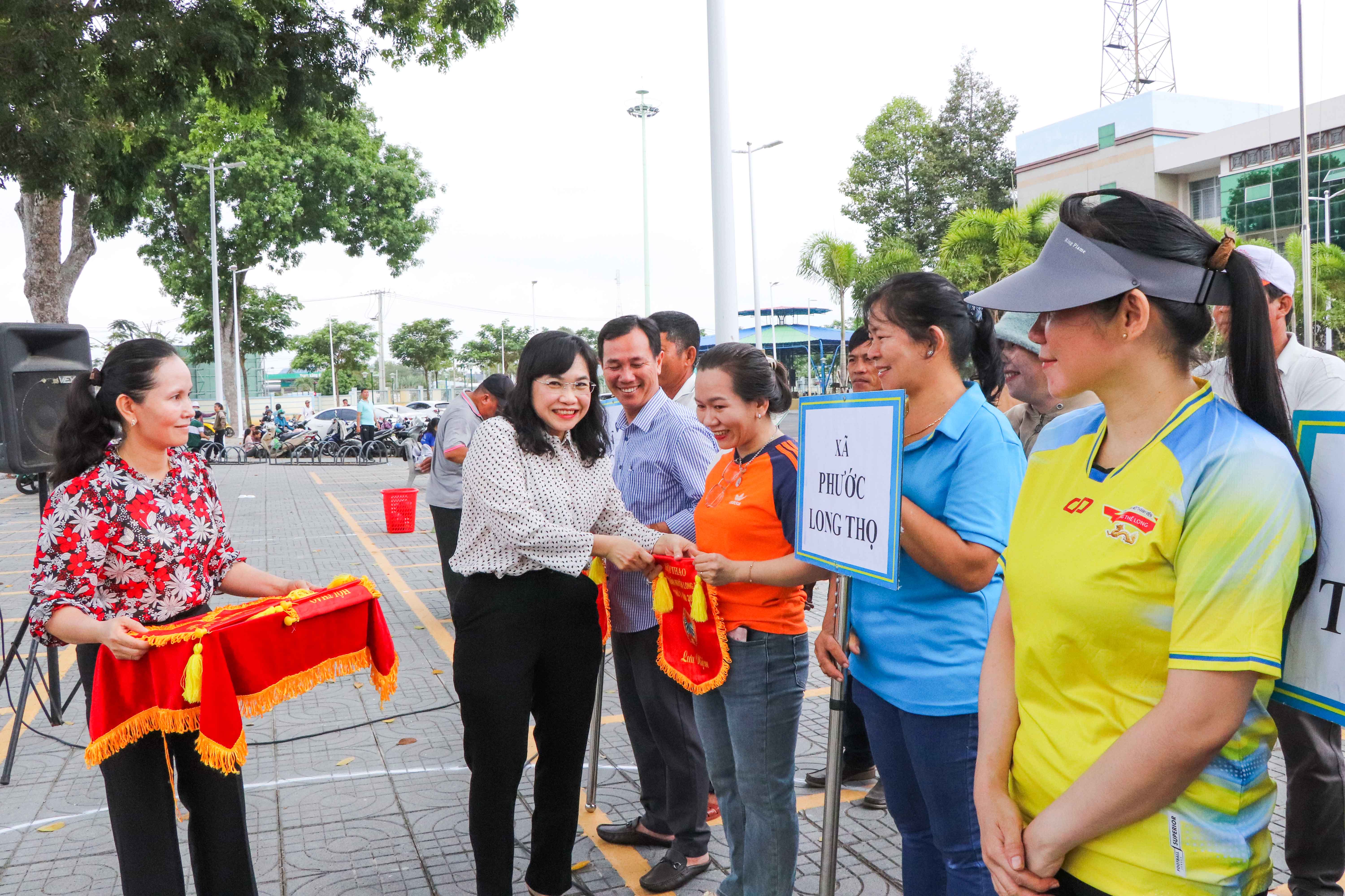 Bà Trương Thị Kim Phượng, Phó Chủ tịch Hội Nông dân tỉnh trao Cờ lưu niệm cho các đội tham gia hội thao.