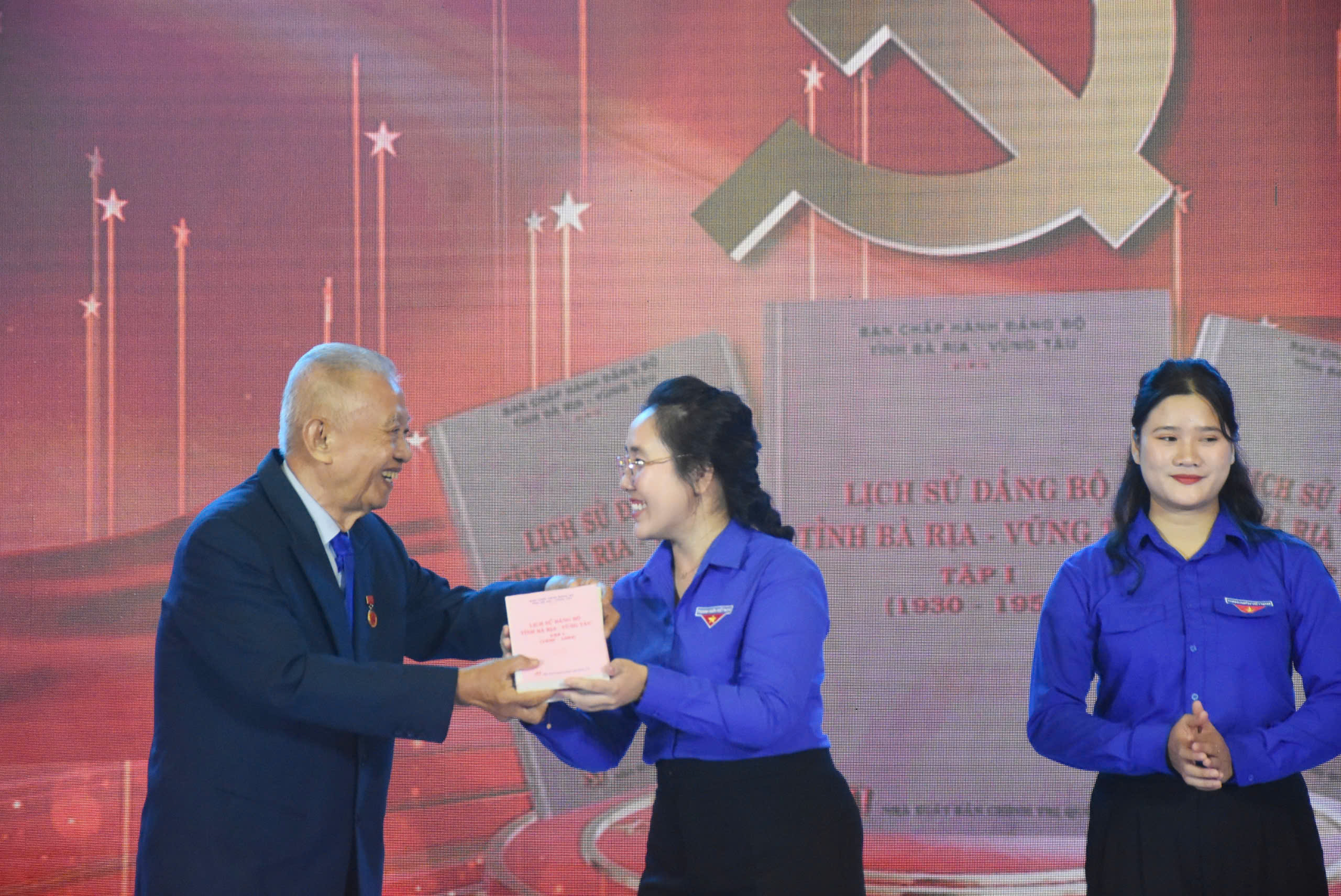Ông Trần Văn Khánh, nguyên Bí thư Tỉnh ủy Bà Rịa-Vũng Tàu, đại diện cho thế hệ tham gia kháng chiến trao bộ Lịch sử Đảng bộ tỉnh Bà Rịa-Vũng Tàu cho đại diện tuổi trẻ của tỉnh.