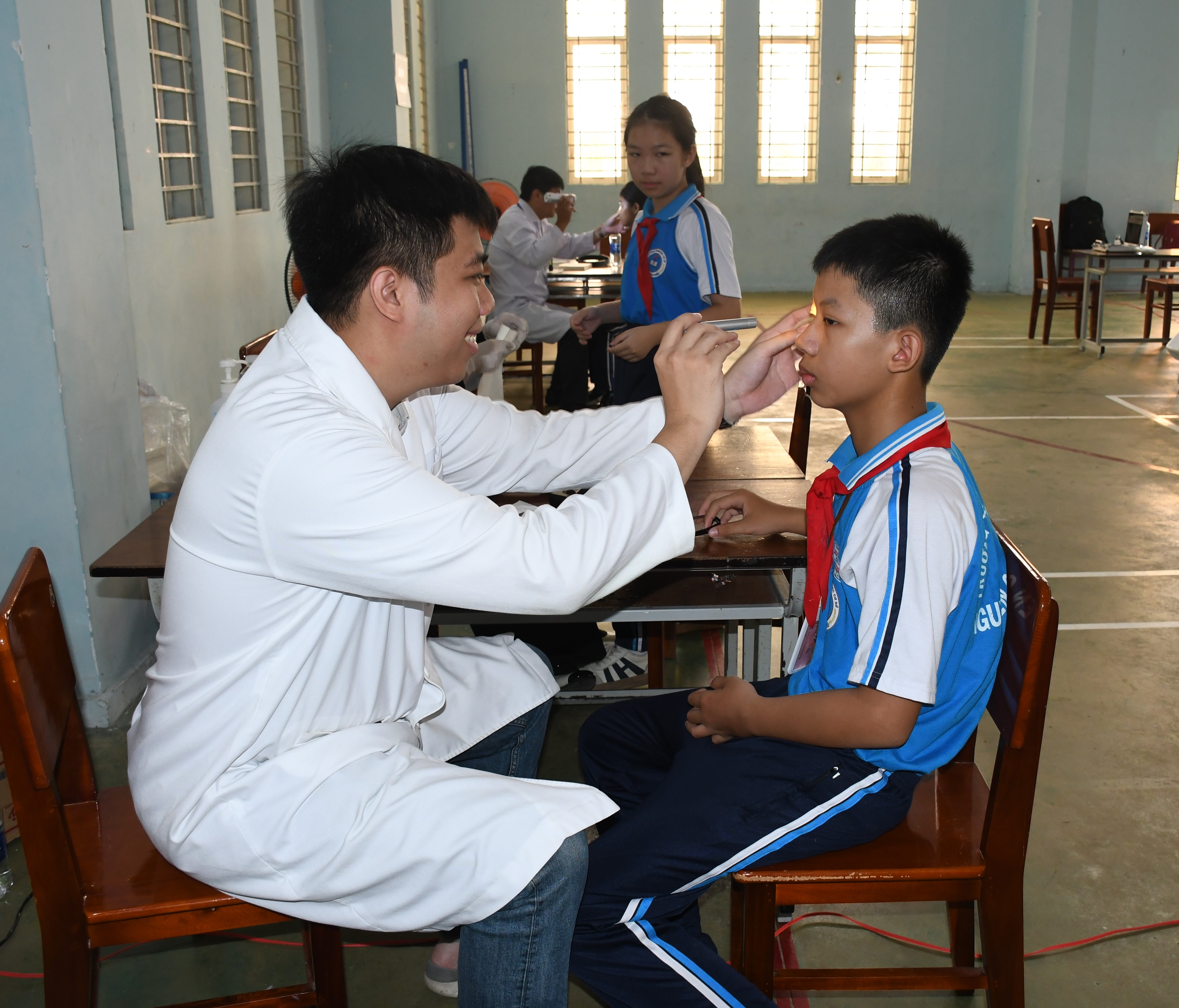 Bác sĩ Bệnh viện Mắt tỉnh khám mặt cho học sinh.