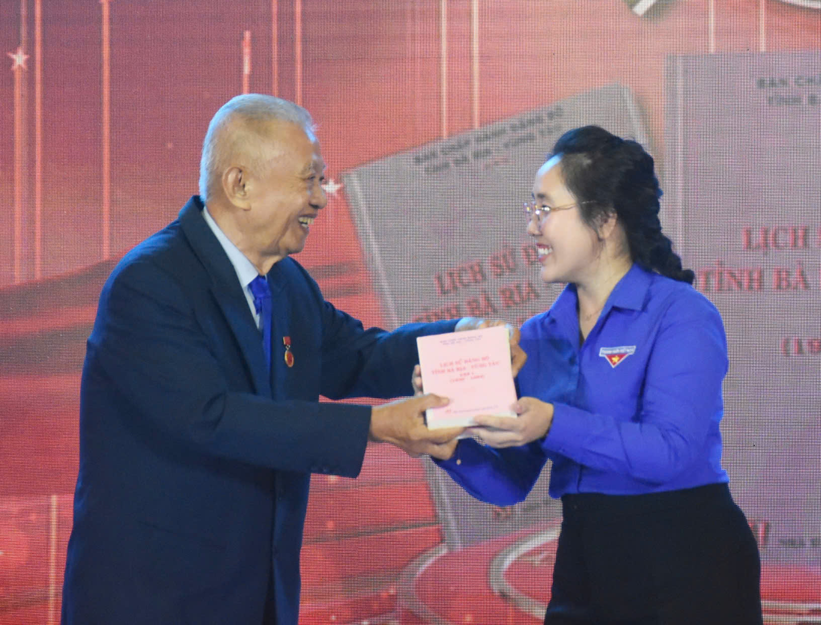 Ông Trần Văn Khánh, nguyên Bí thư Tỉnh ủy Bà Rịa-Vũng Tàu, đại diện cho thế hệ tham gia kháng chiến trao cuốn Lịch sử Đảng bộ tỉnh Bà Rịa-Vũng Tàu cho đại diện tuổi trẻ của tỉnh.