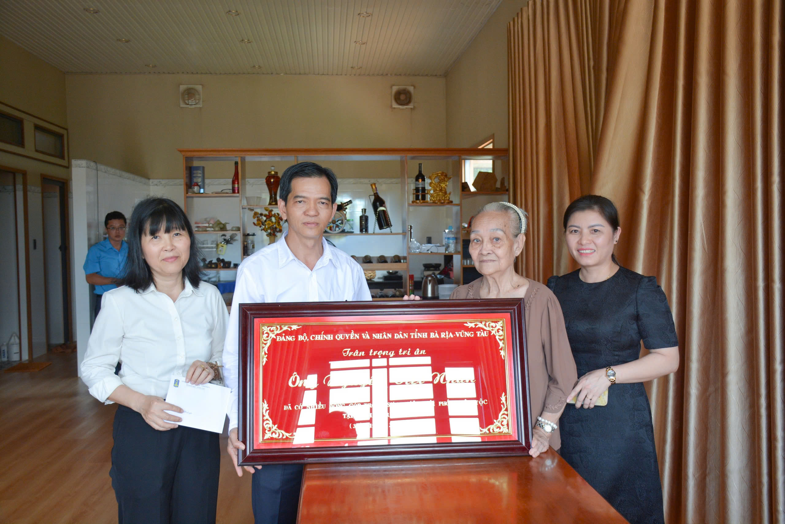 Ông Dương Trọng Hiếu, TUV, Trưởng Ban Tổ chức Tỉnh ủy tặng khánh vàng tri ân cho bà Phạm Thị Phương Hiền là vợ ông Nguyễn Việt Nhân, Nguyên Ủy viên BTV Tỉnh ủy, Nguyên Trưởng Ban Tổ chức Tỉnh ủy. Ảnh: TRẦN TIẾN