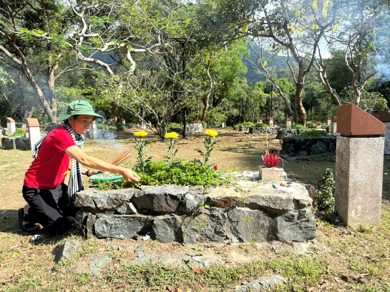 Anh Nguyễn Quang Trường đến từ tỉnh Sóc Trăng kính cẩn rải nắm đất mẹ lên phần mộ các liệt sĩ yên nghỉ  tại Nghĩa trang Hàng Dương quê ở tỉnh Sóc Trăng.