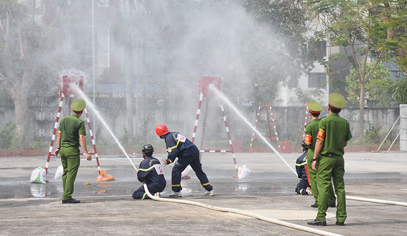 Các vận động viên tham gia phần thi cứu nạn cứu hộ trong môi trường có khói, khí độc kết hợp sử dụng máy bơm chữa cháy phun tiêu điểm.