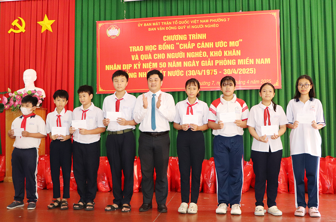 Ông Nguyễn Công Thành, Bí thư Đảng ủy phường 7 trao học bổng tới các em HS.