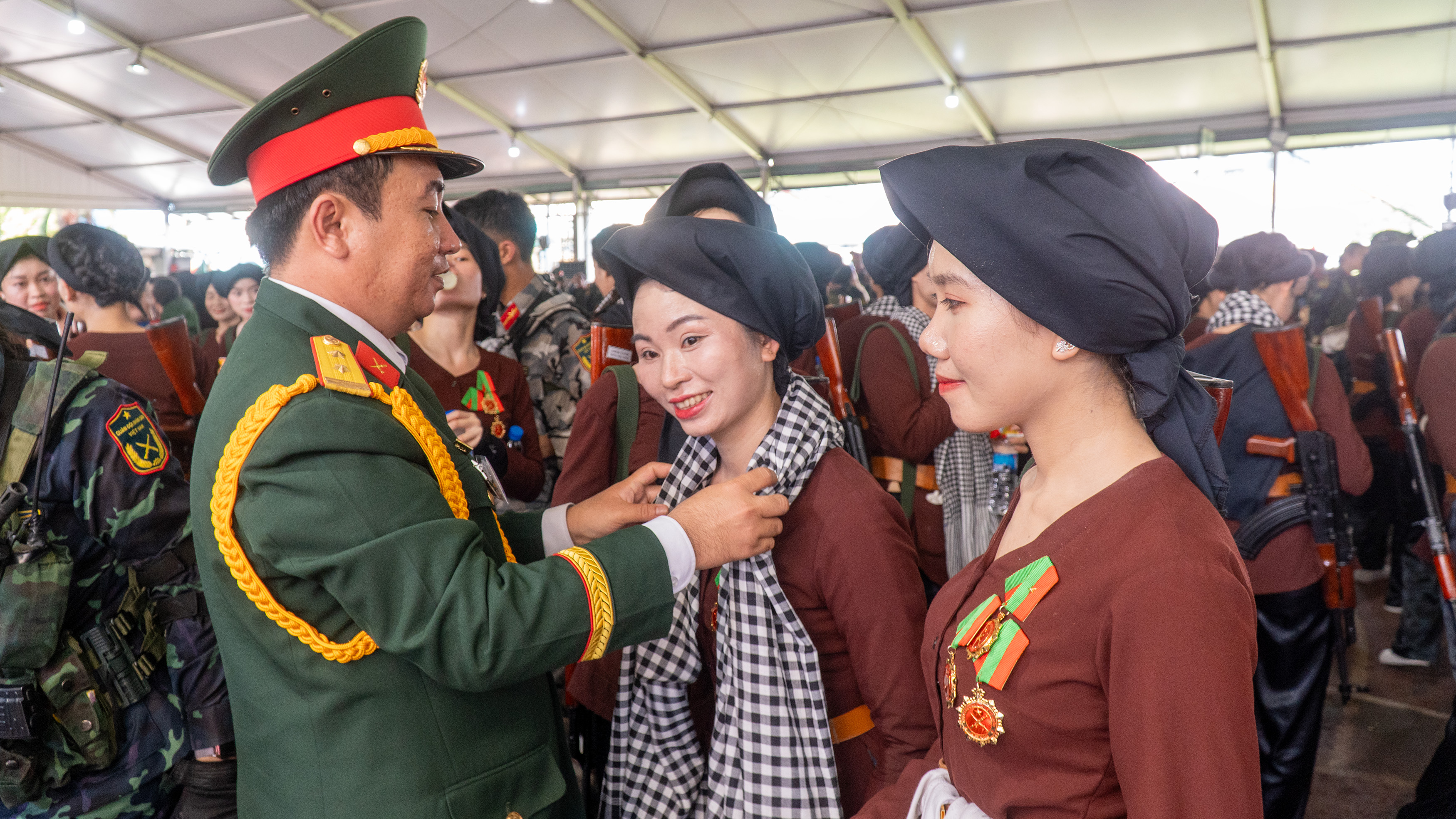 Trung tá Ngô Khánh, Chính ủy Bộ Chỉ huy Quân sự tỉnh tặng những chiếc khăn rằn - món quà quà miền Nam yêu thương gửi đến các nữ cán bộ, chiến sĩ khối nữ du kích miền Bắc.