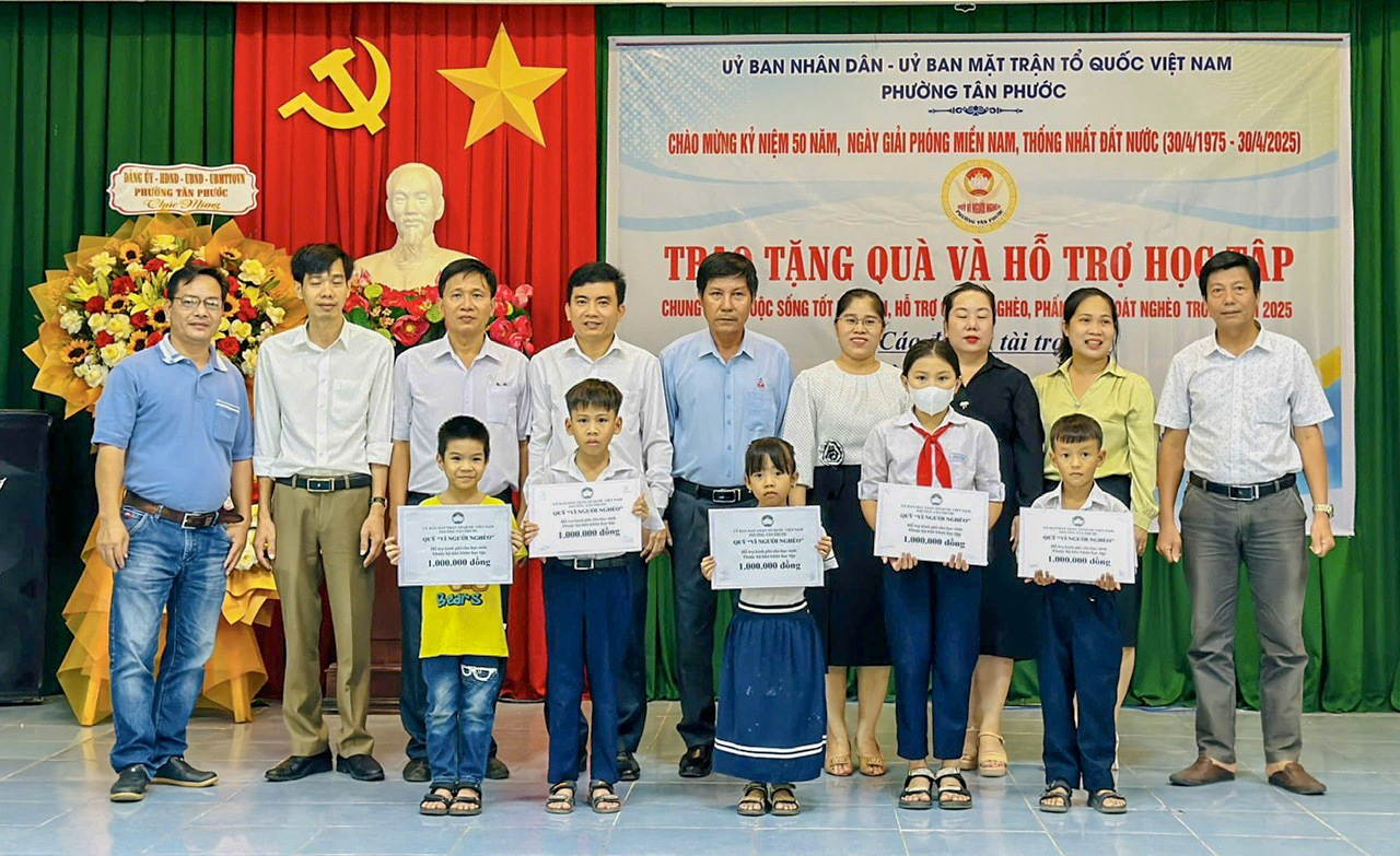 Đại diện phường Tân Phước, TP.Phú Mỹ và nhà tài trợ trao tiền hỗ trợ học tập tới các em học sinh.