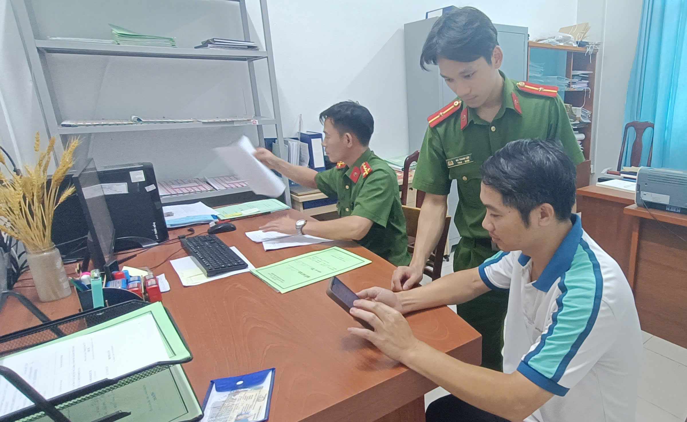 Cán bộ công an xã Phước Hưng (huyện Long Đất) hướng dẫn người dân nộp hồ sơ trực tuyến cấp, đổi  chứng nhận đăng ký xe, biển số xe ô tô.