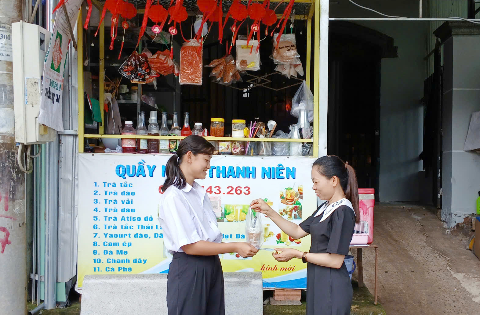 Chị Nguyễn Thị Yến (phải) và quầy nước nhỏ phục vụ khách.