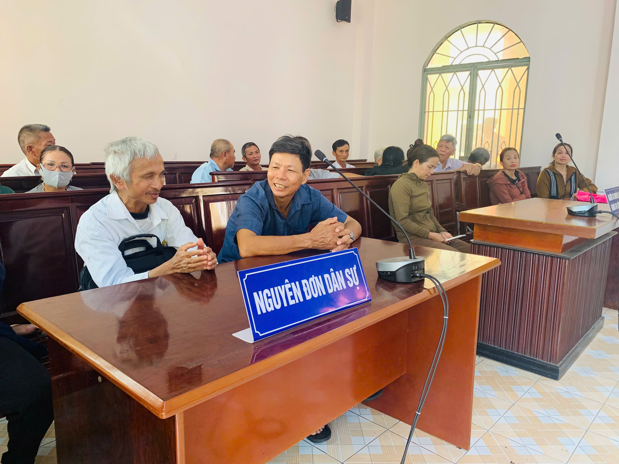 Ông Nguyễn Văn Thiệt (xã Hòa Hiệp, huyện Xuyên Mộc, trái) - người khiếm thị trao đổi với nhân chứng tại phiên tòa ở Tòa án Nhân dân huyện Xuyên Mộc.