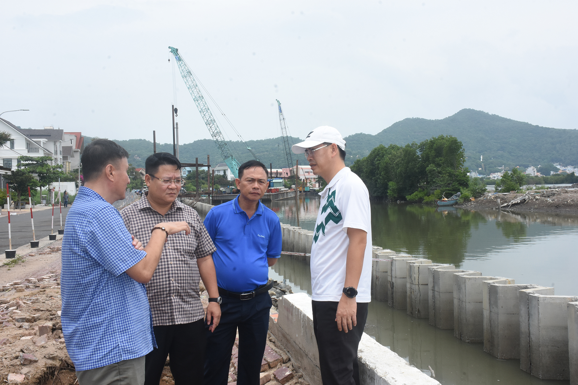 Lãnh đạo phường Tam Thắng cùng cơ quan chức năng khảo sát thực địa dự án nạo vét kênh Bến Đình do người dân phản ánh việc thi công gây rung lắc. Ảnh: QUANG VŨ