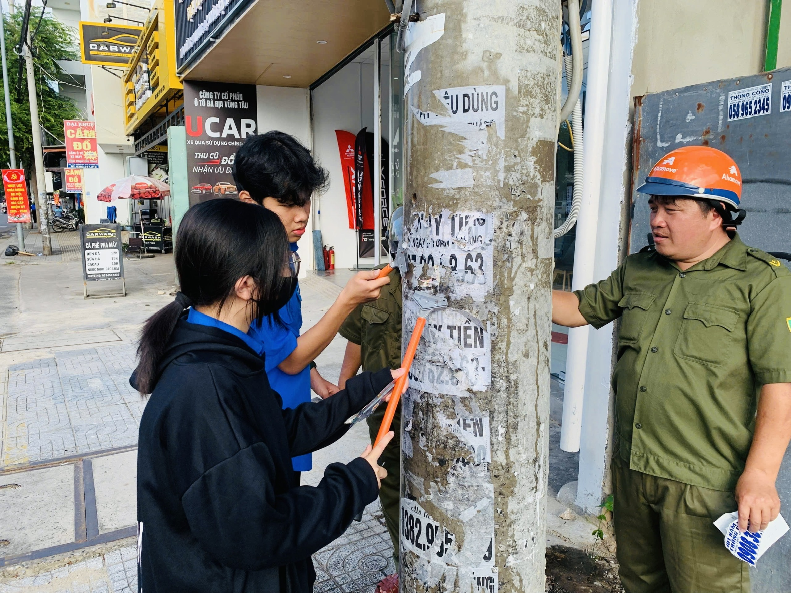 Đoàn viên thanh niên gỡ bỏ quảng cáo rao vặt dán trên cột điện.